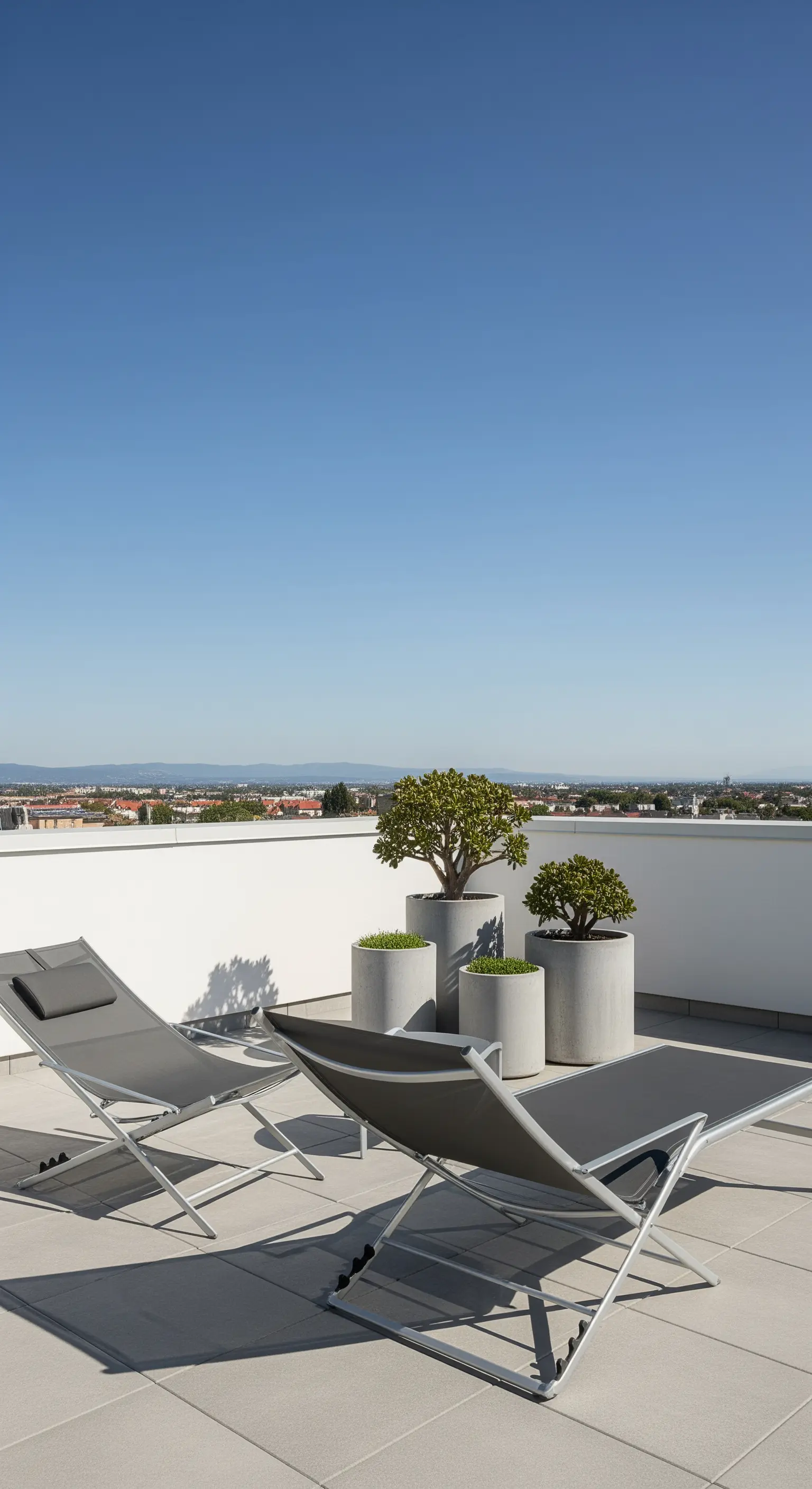 Terrazza moderna con due sdraio grigie e un gruppo di vasi cilindrici in cemento.