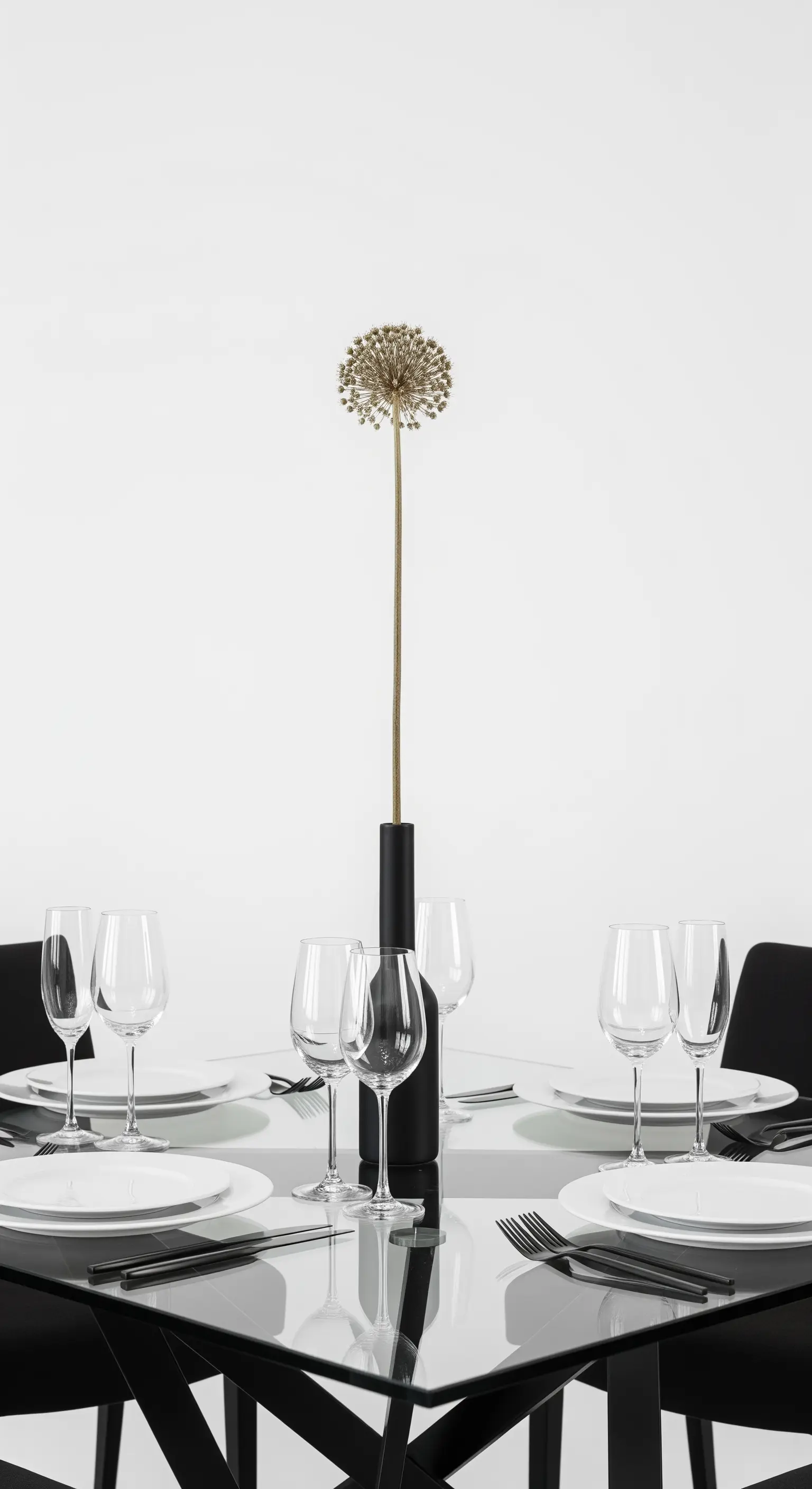 Tavola minimalista con un singolo fiore essiccato in un vaso alto.