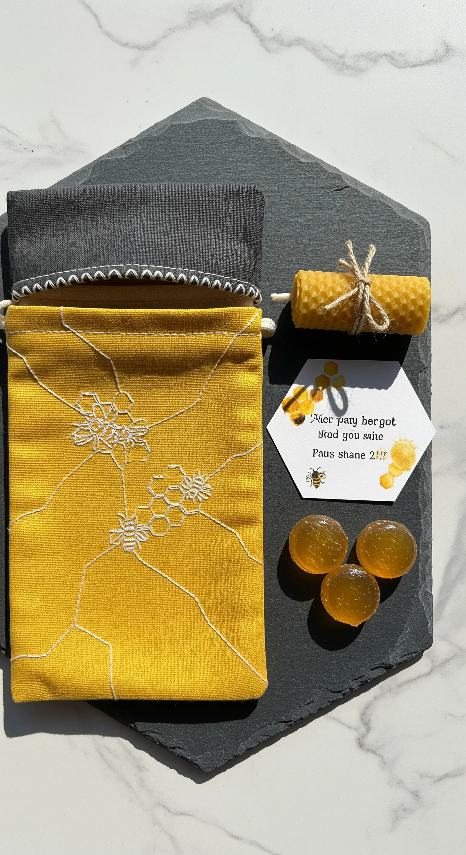 Sacchetto giallo con ricamo a nido d'ape, caramelle al miele e una candela in cera d'api.