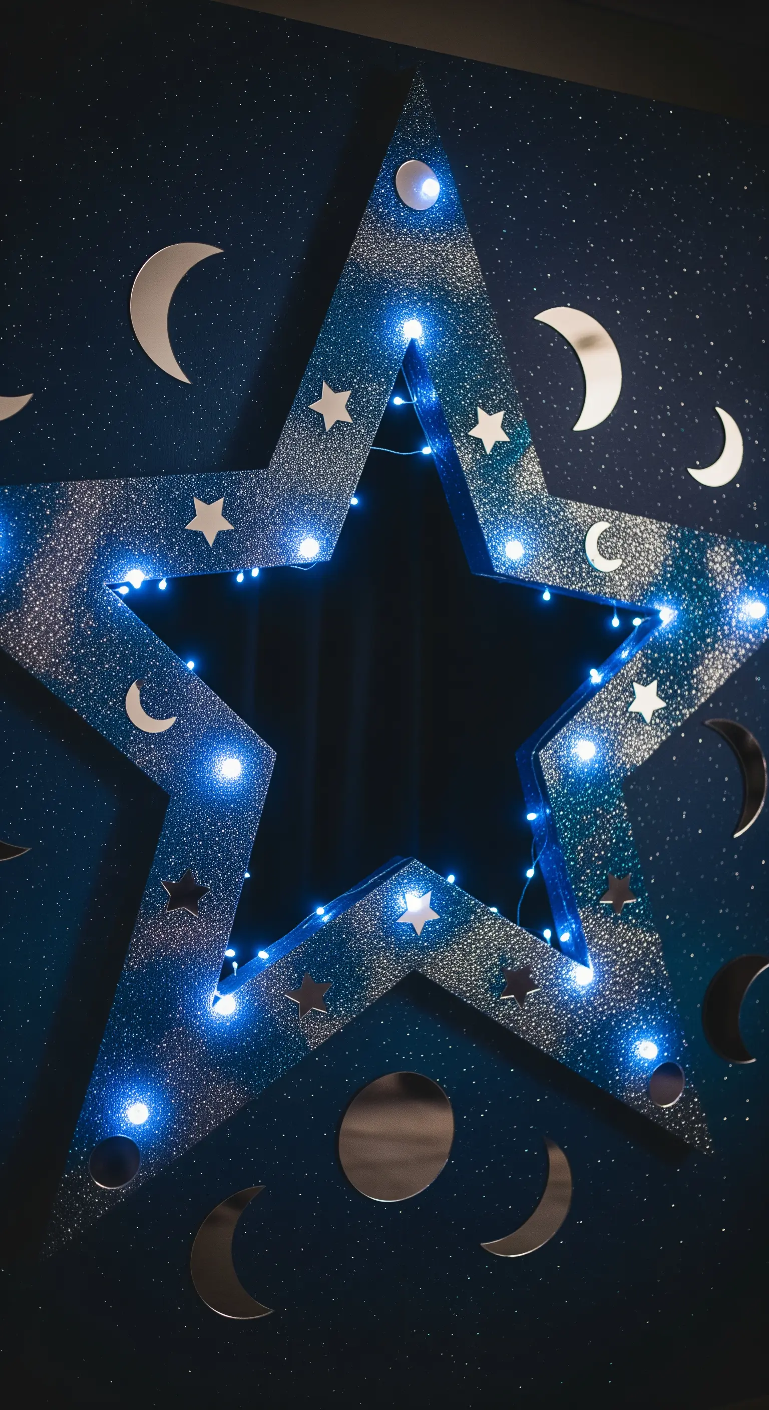 Cornice per photobooth a forma di stella blu glitterata con lucine e specchi a tema lunare.
