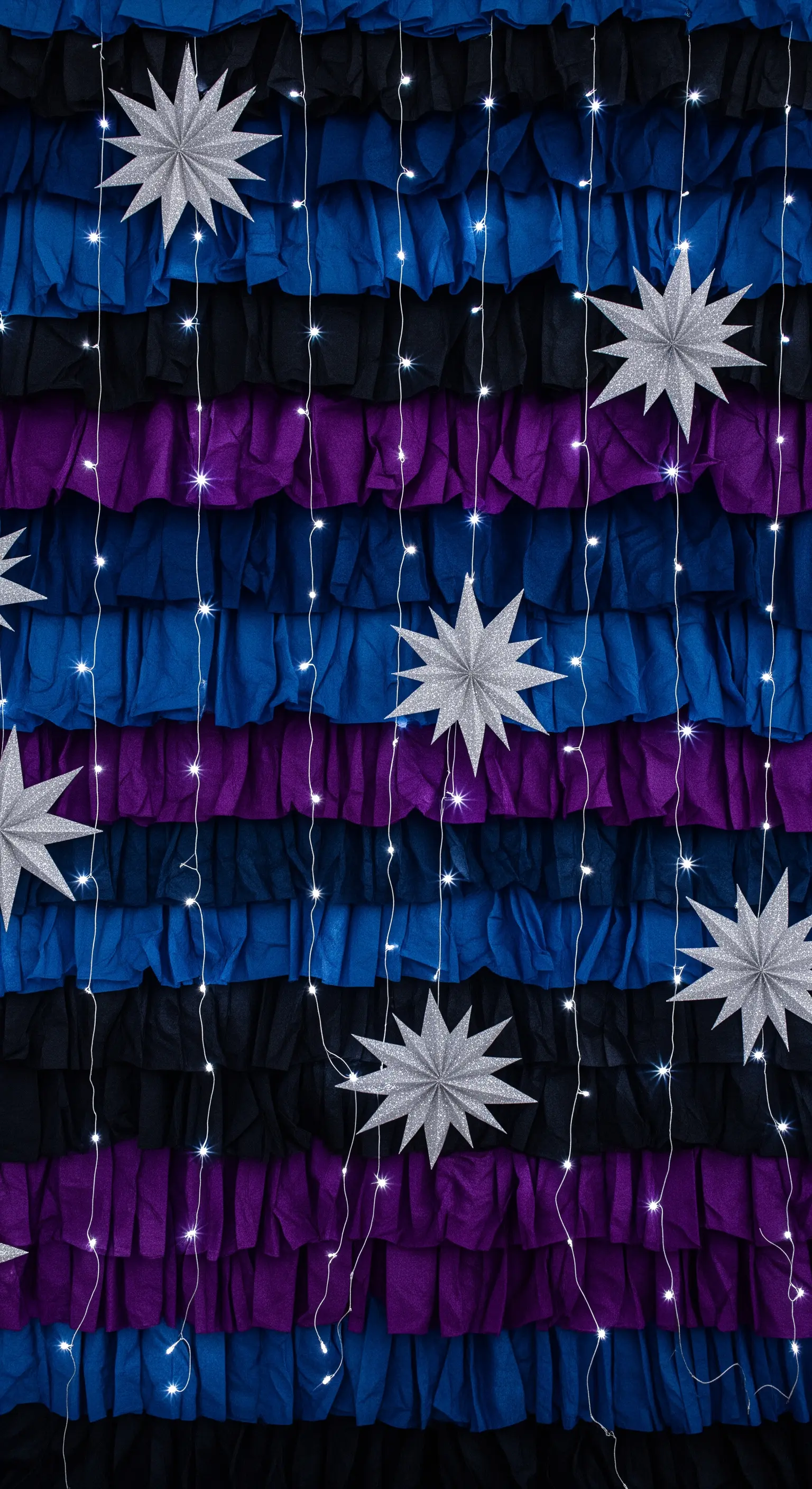 Backdrop a fasce orizzontali blu, viola e nere con stelle argentate e lucine fredde.