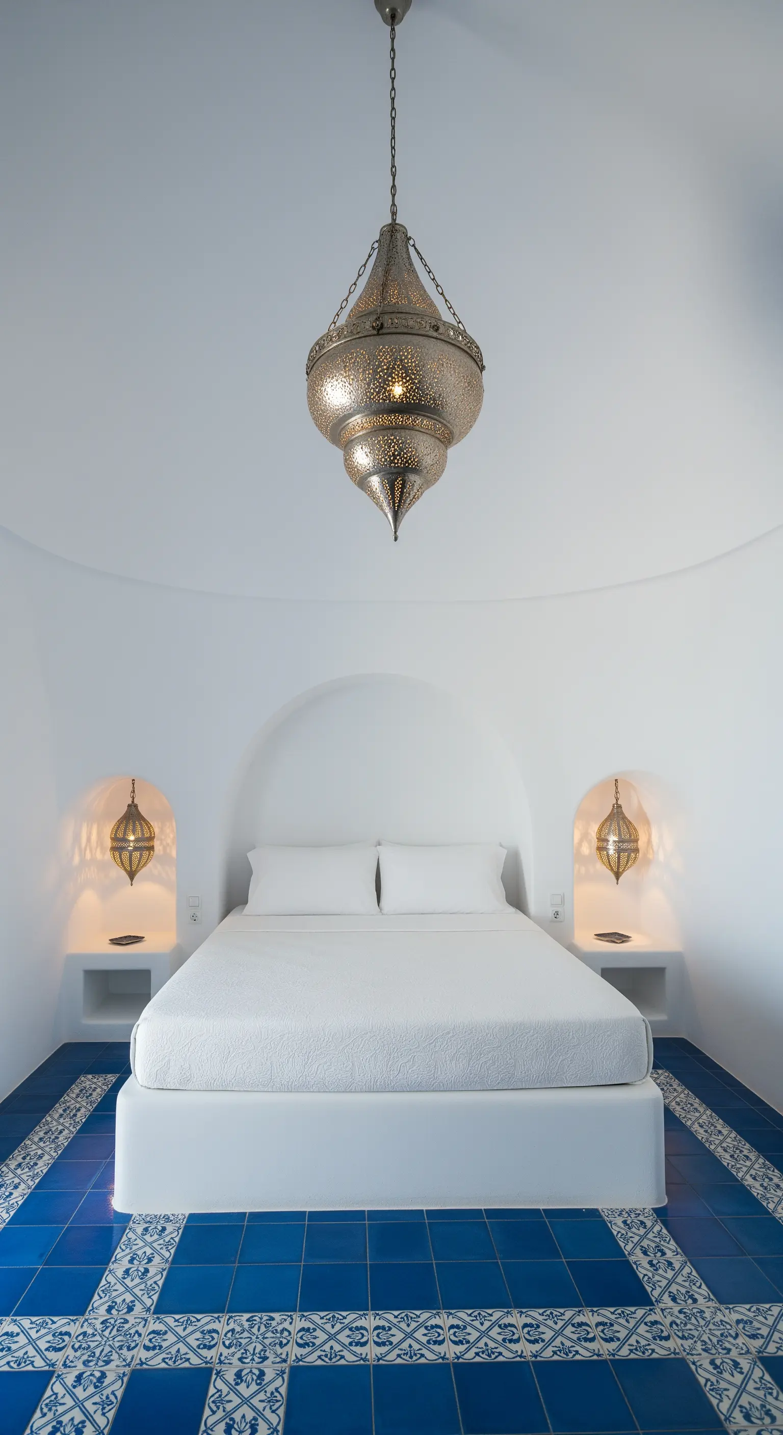 Lanterna marocchina in metallo traforato in una camera da letto bianca e blu in stile greco.