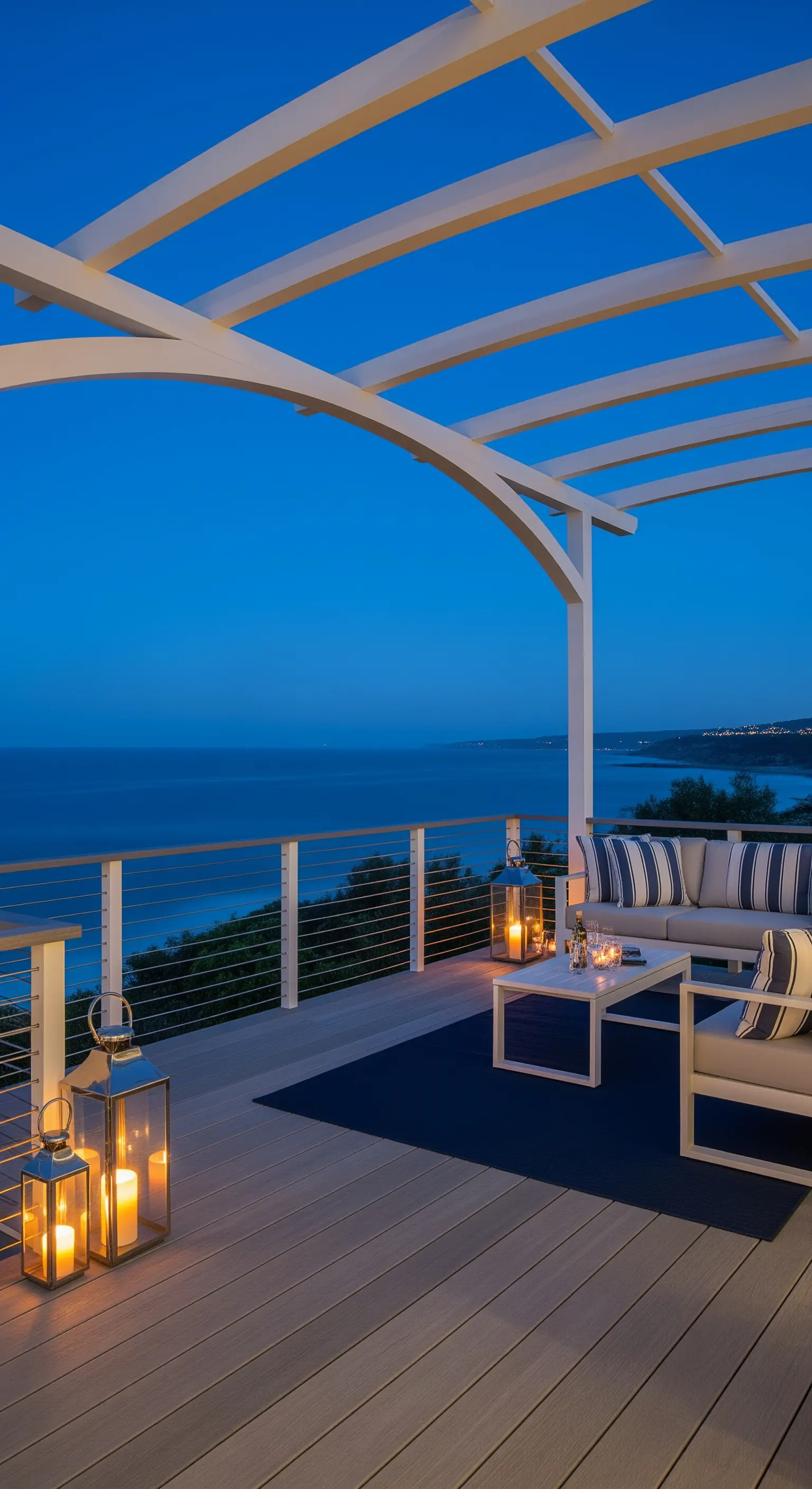 Terrazza moderna sul mare con pergola bianca dal design curvo e divano a righe.