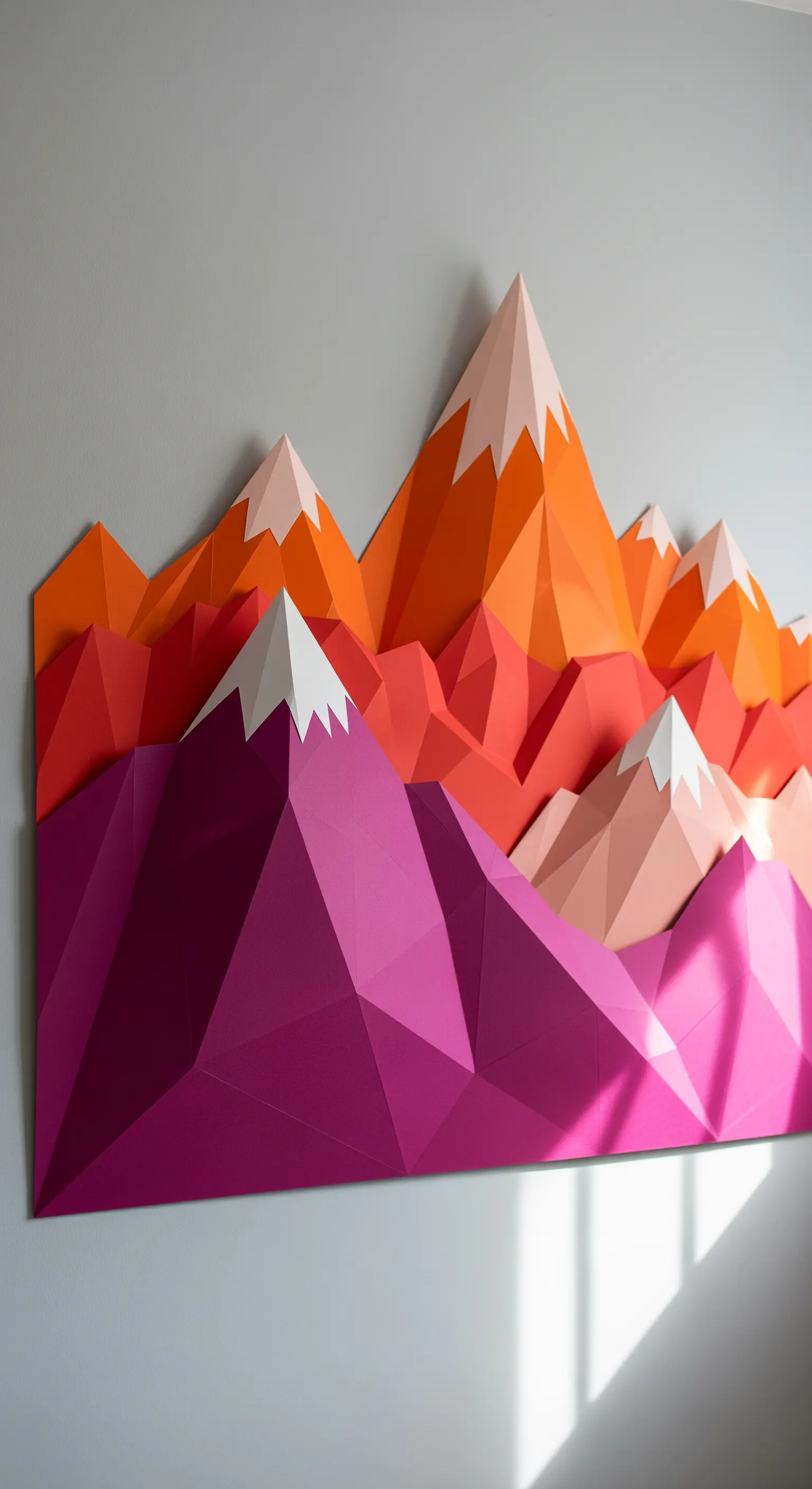 Decorazione murale 3D a forma di montagne poligonali in tonalità calde.