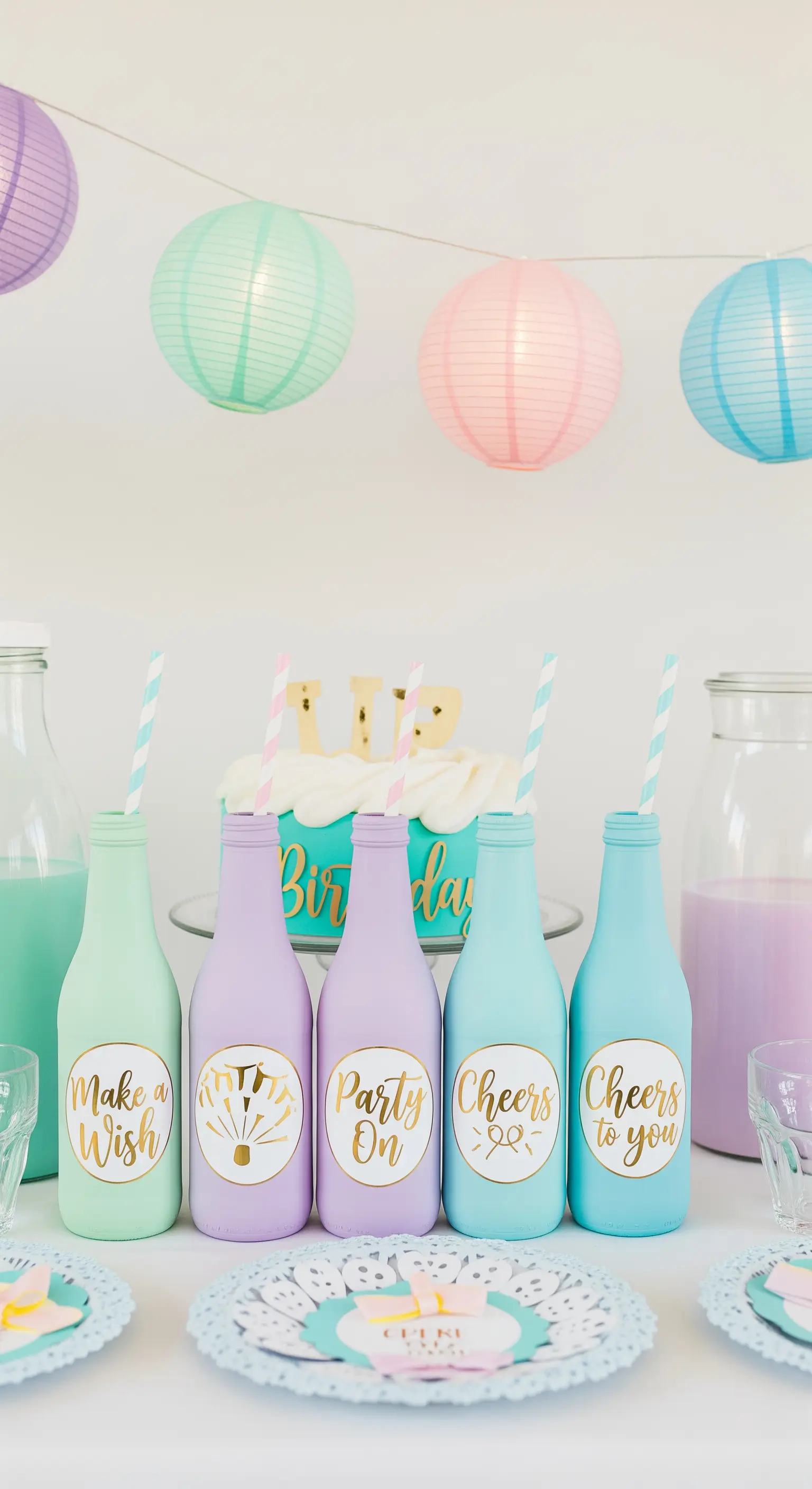 Bottigliette di vetro dipinte in colori pastello opachi con etichette adesive dorate.