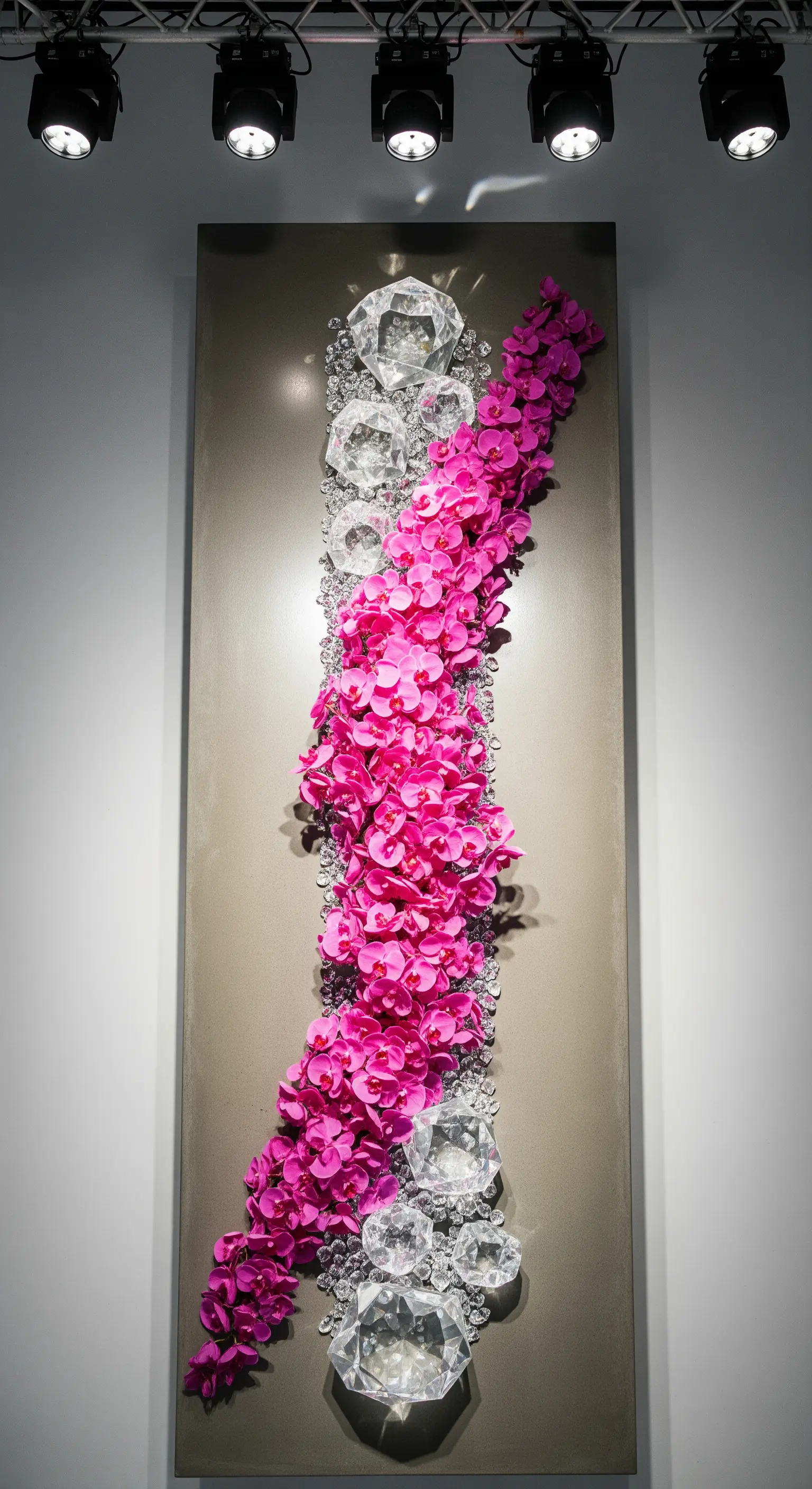 Installazione artistica a parete con cristalli giganti e una cascata di orchidee fucsia.