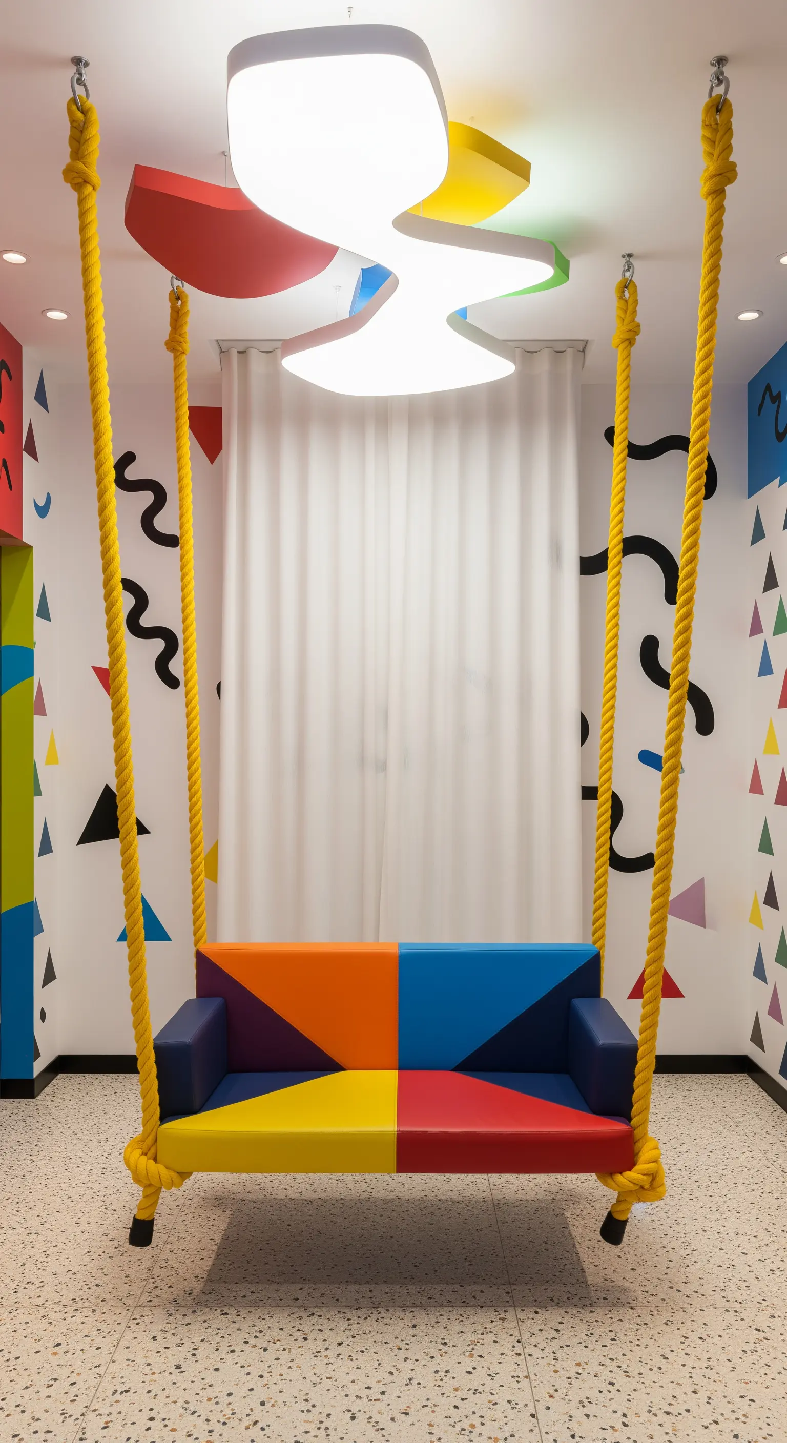 Divanetto sospeso color-block con corde gialle in una stanza con decorazioni stile Memphis.