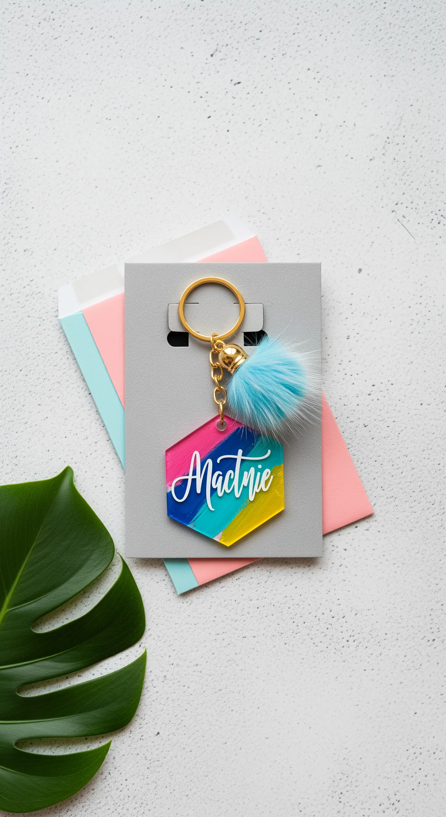 Portachiavi personalizzato in acrilico colorato con nome e pon-pon azzurro.