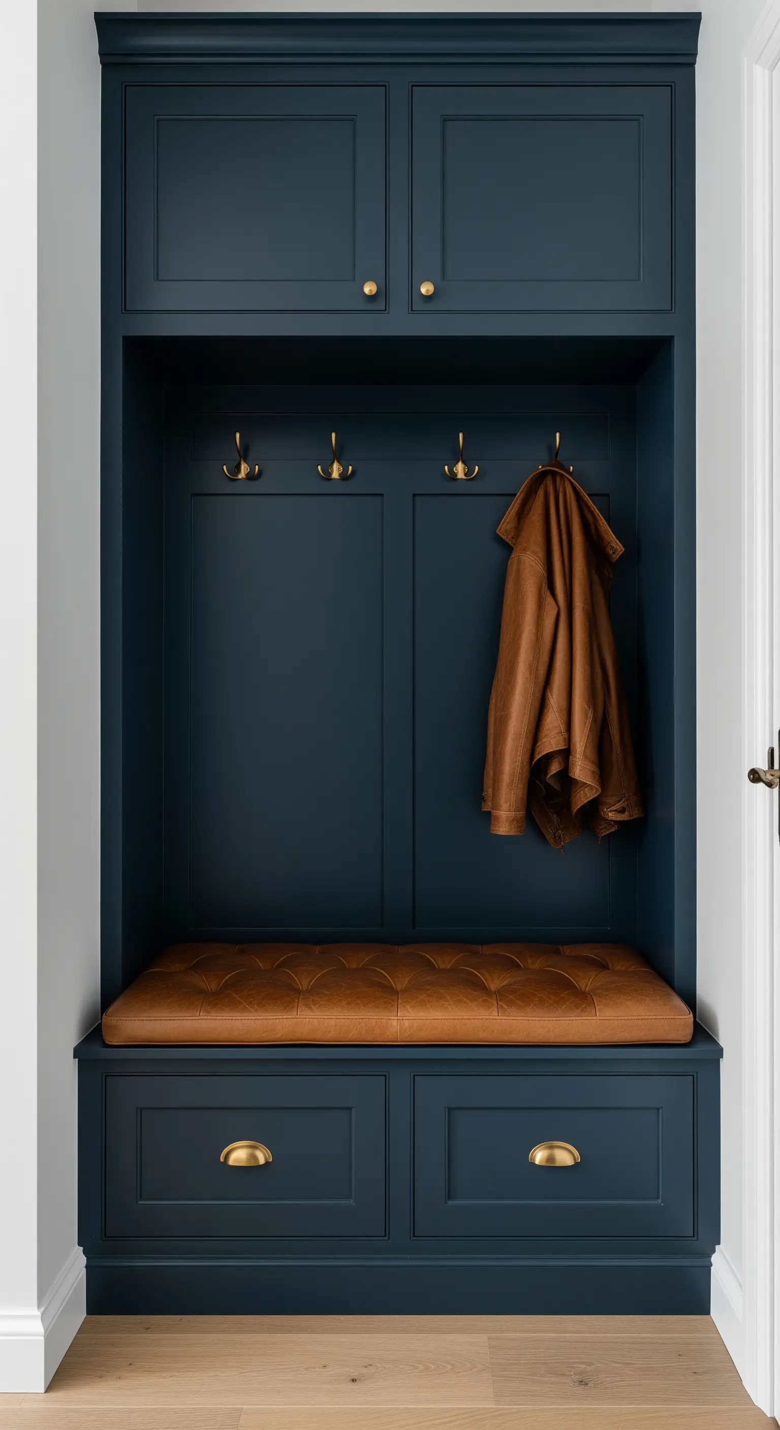 Mobile da ingresso su misura blu navy con cuscino in pelle marrone e ferramenta in ottone.