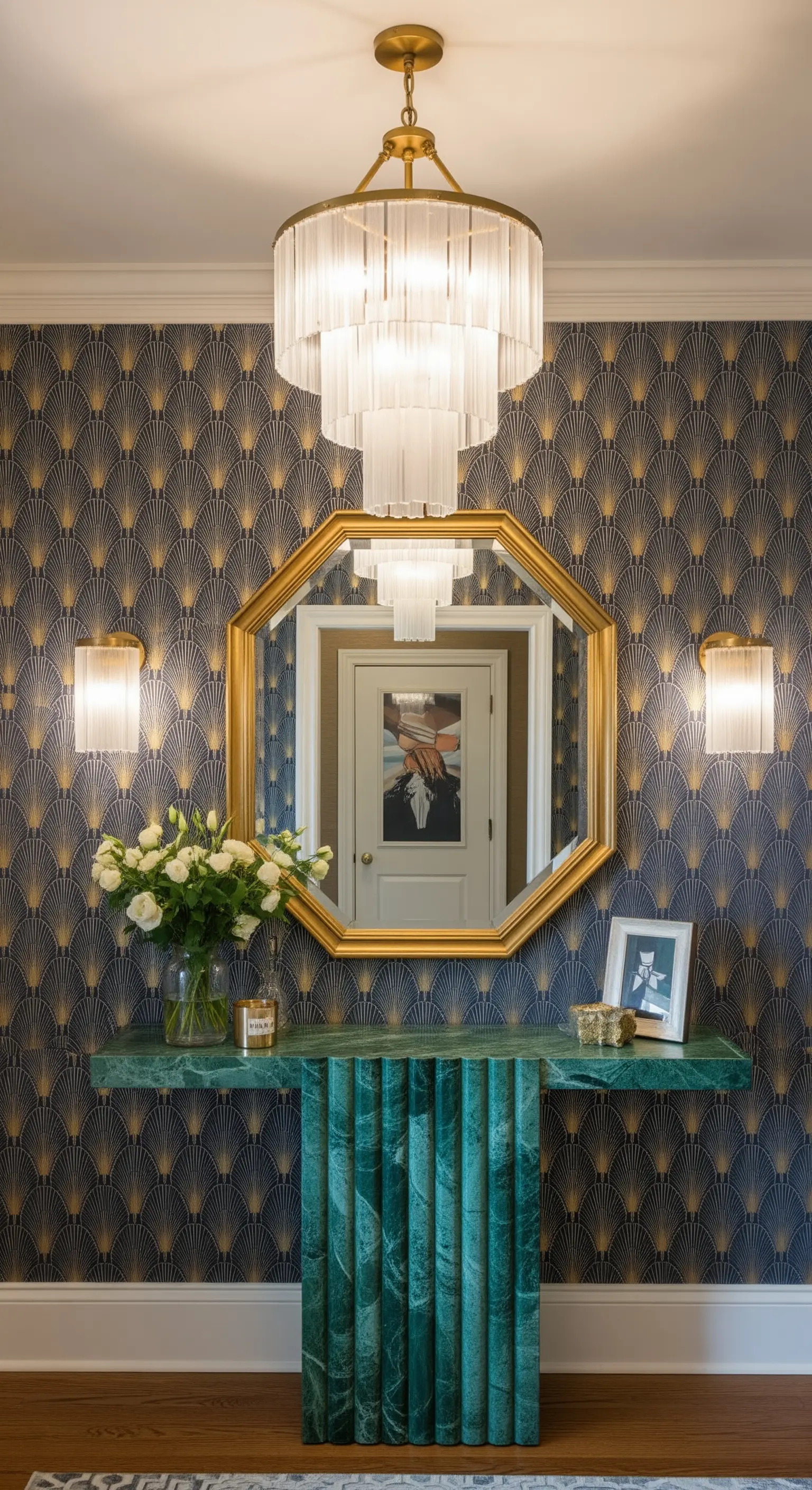 Ingresso Art Déco con carta da parati a ventaglio, specchio ottagonale e consolle in marmo verde.