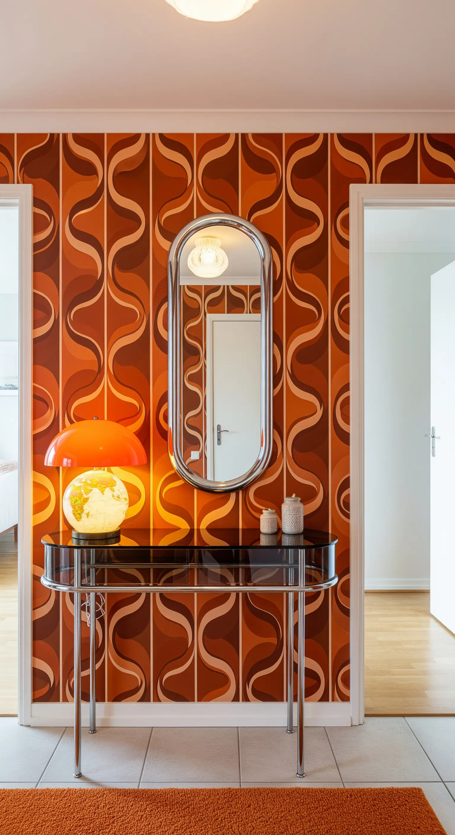 Ingresso in stile anni '70 con carta da parati optical, consolle cromata e lampada arancione.