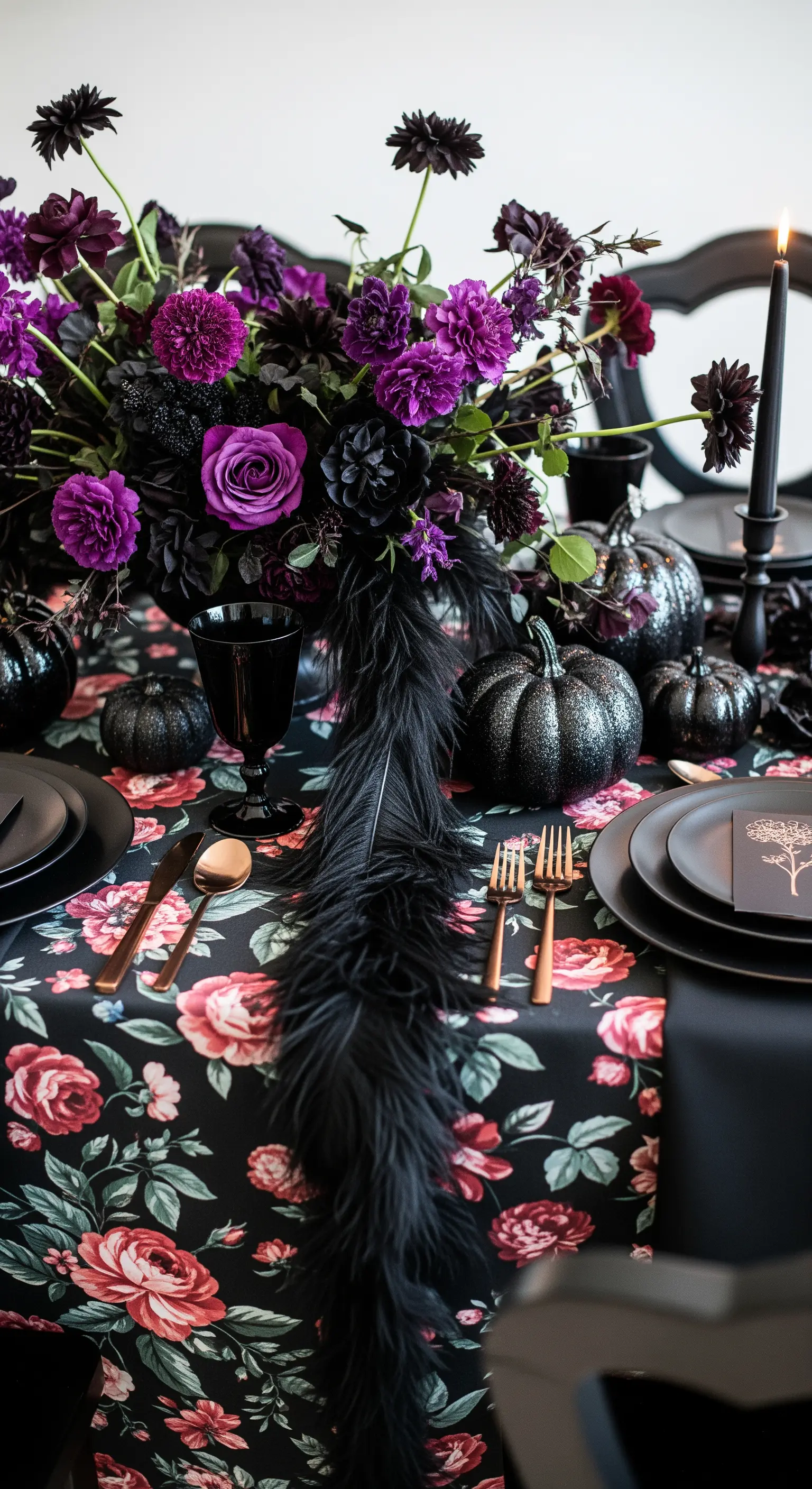 Tovaglia floreale scura con zucche nere, piume e fiori viola.