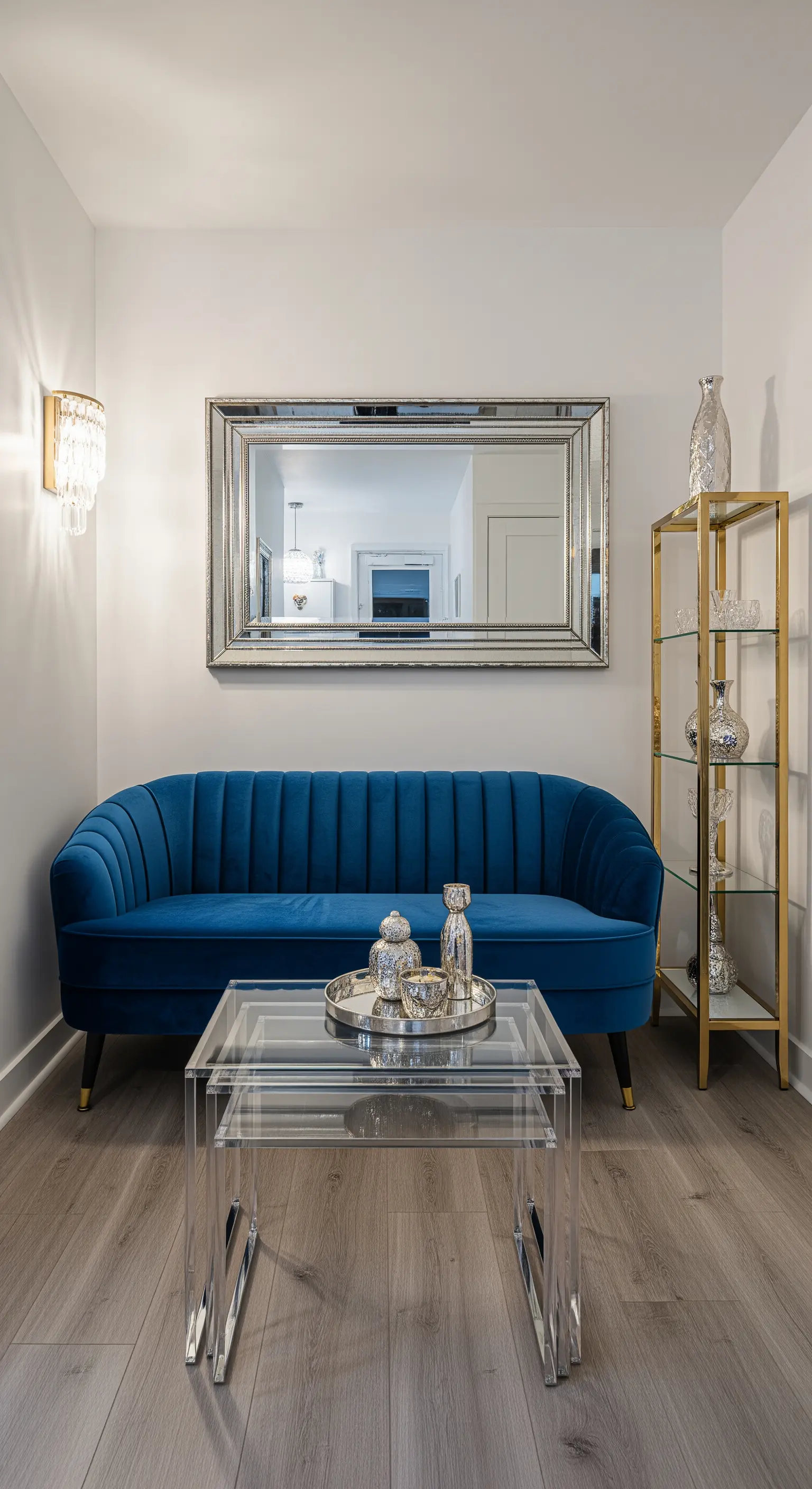 Mini-salotto con divano blu, specchio e tavolini in acrilico trasparente