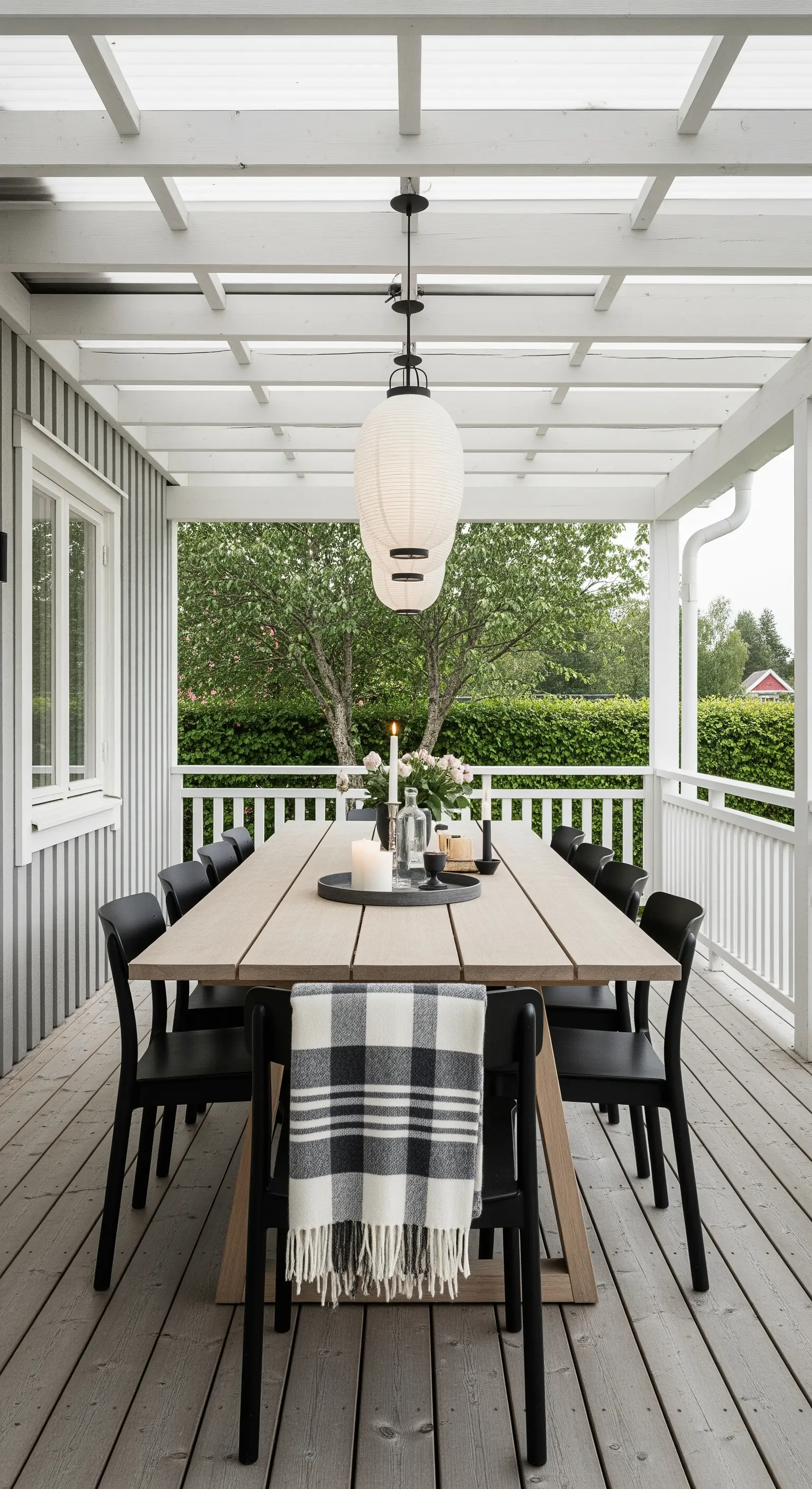 Tavolo da pranzo in legno sotto un portico con una grande lanterna di carta sospesa