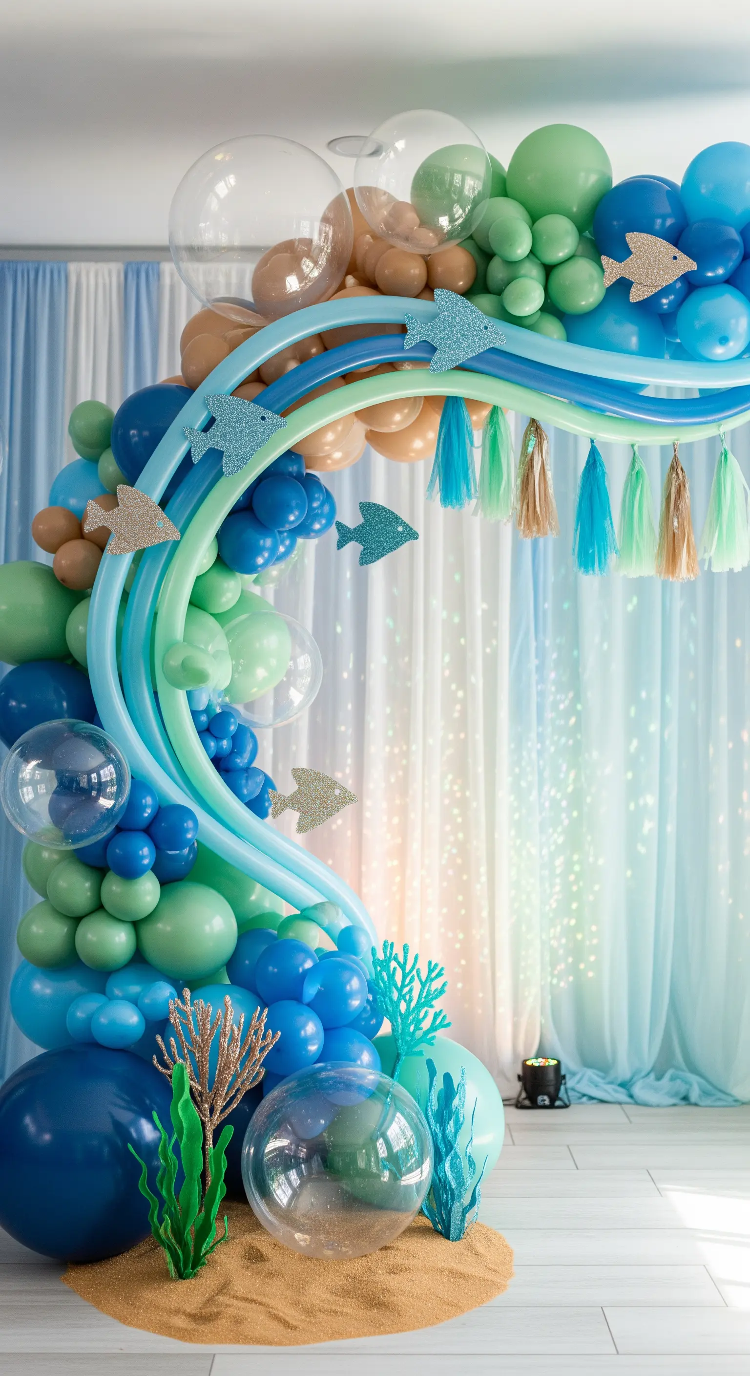 Arco di palloncini a tema marino con onde, pesci glitterati e coralli.