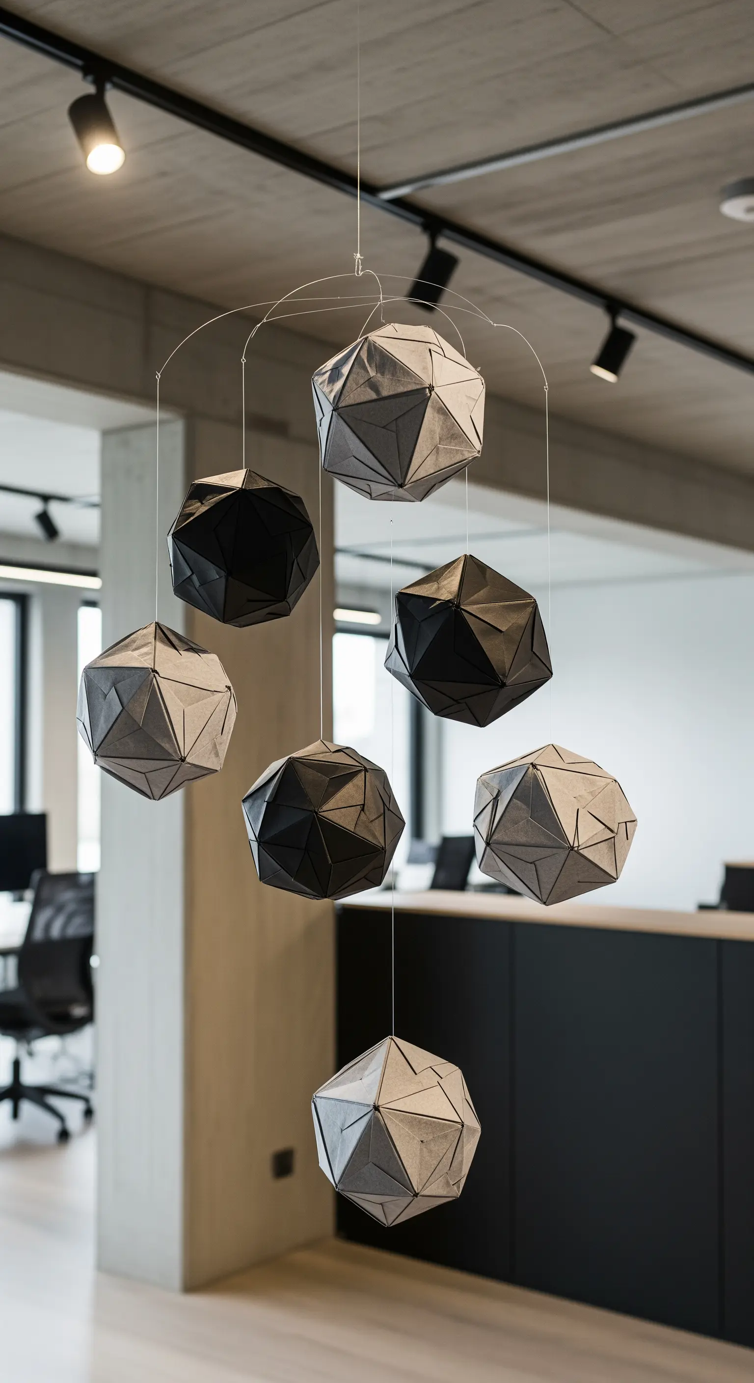 Mobile moderno con solidi geometrici di carta neri e grigi in un ufficio.