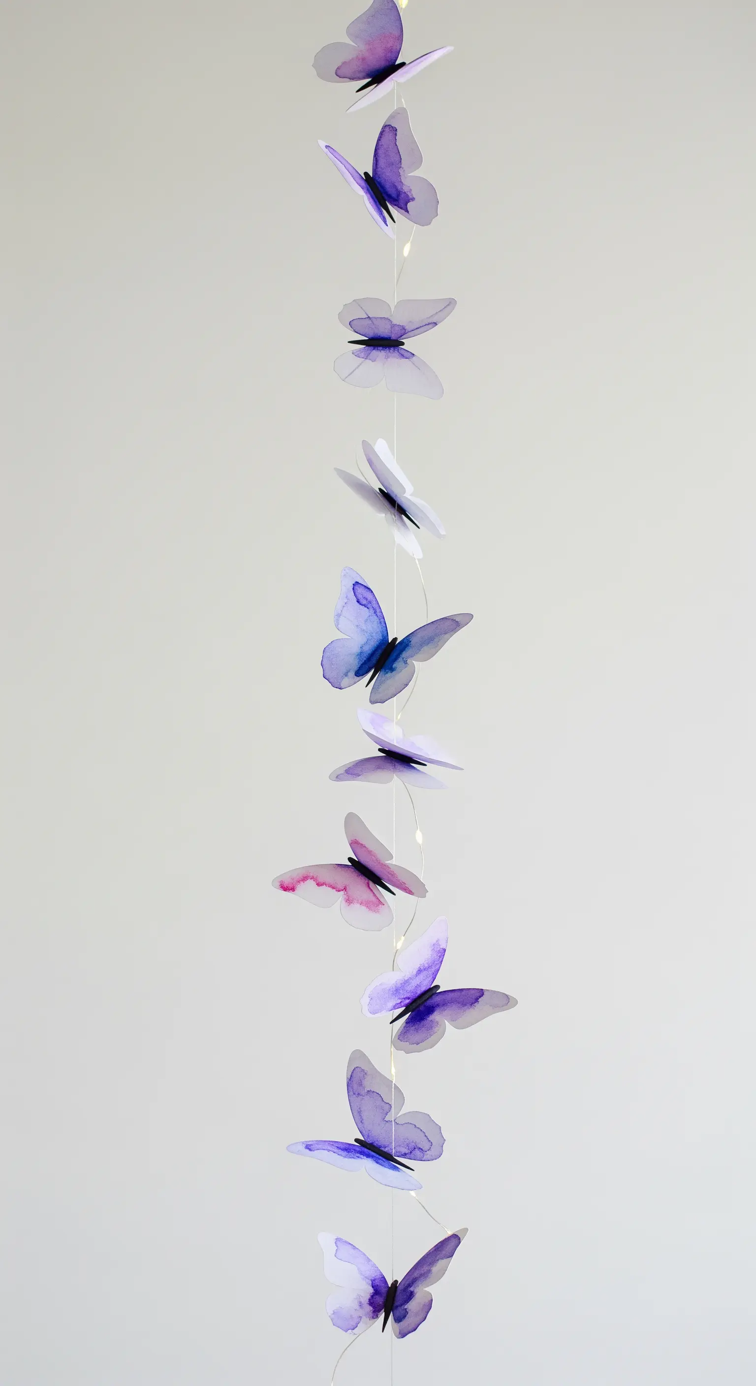 Ghirlanda verticale di farfalle di carta con effetto acquerello e piccole luci a led.