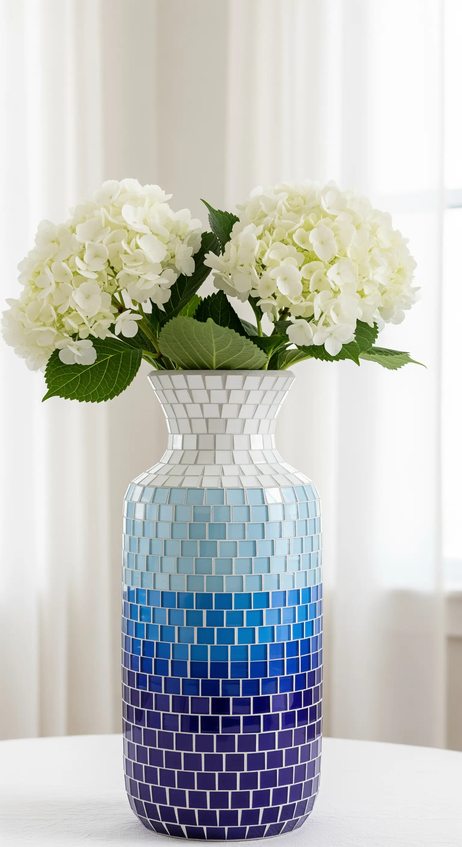 Vaso a mosaico con tessere quadrate che creano un effetto sfumato dal blu scuro al bianco.