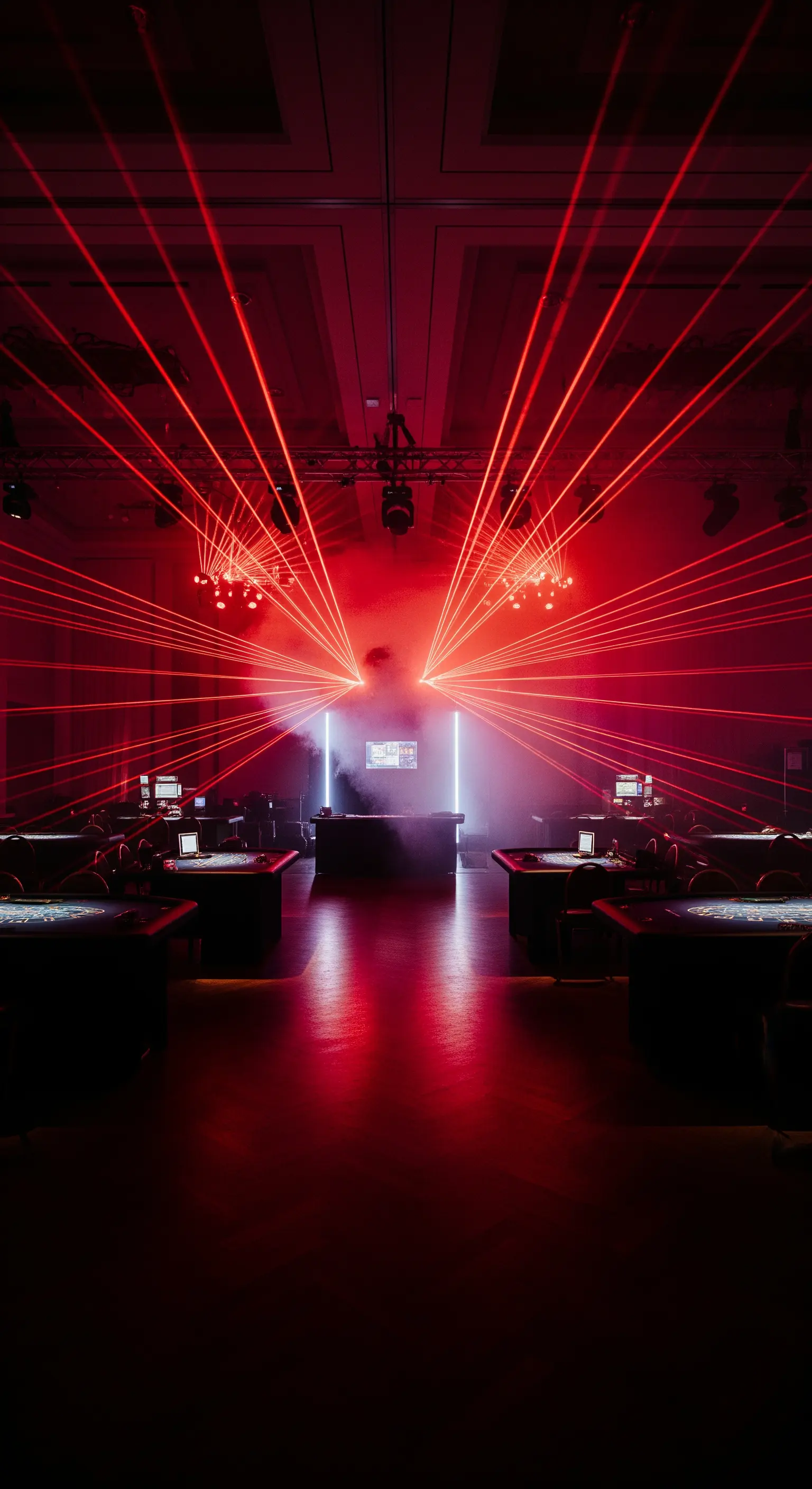 Sala da gioco immersa nel buio, attraversata da decine di raggi laser rossi e luminosi.