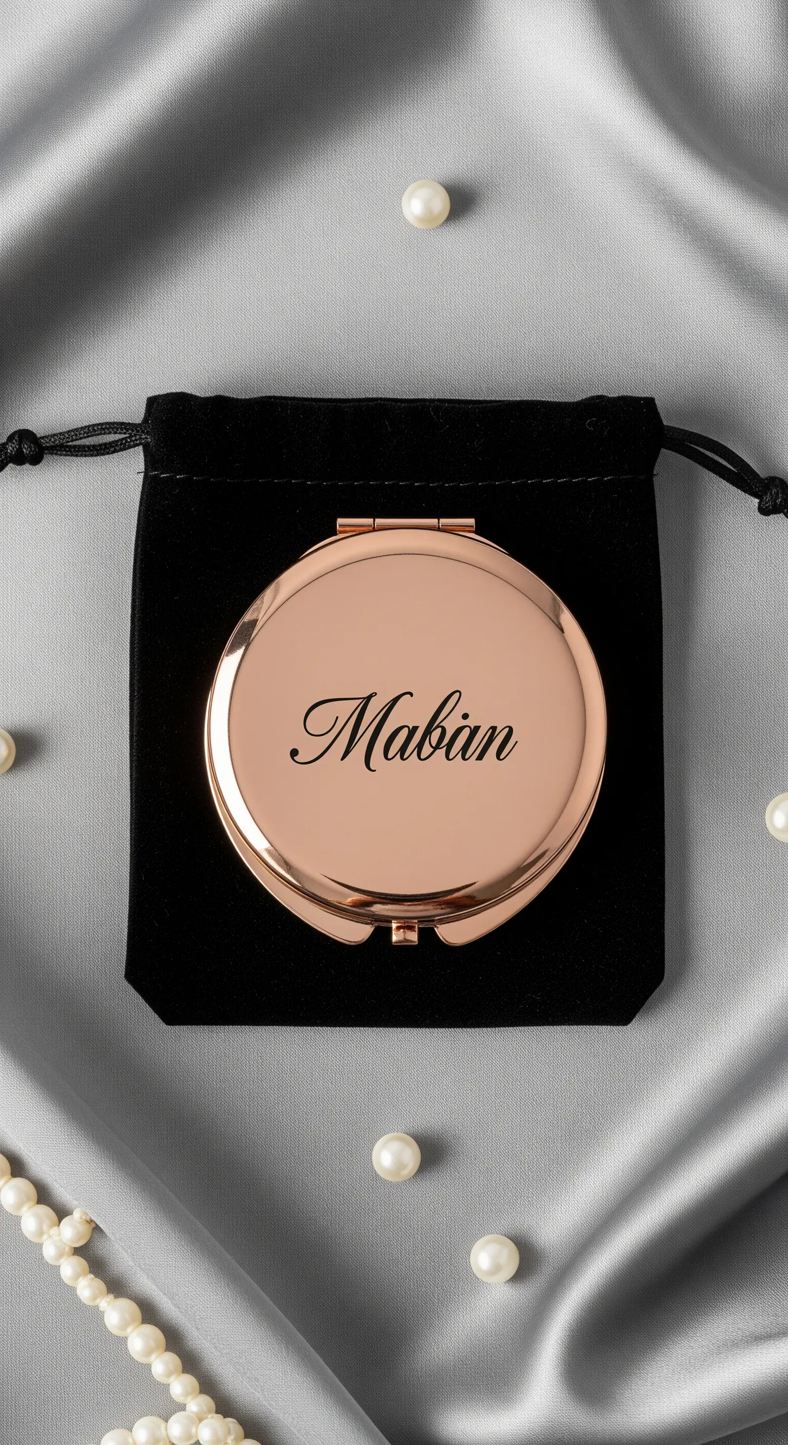 Specchietto da borsetta color oro rosa personalizzato con un nome e custodito in un sacchetto.