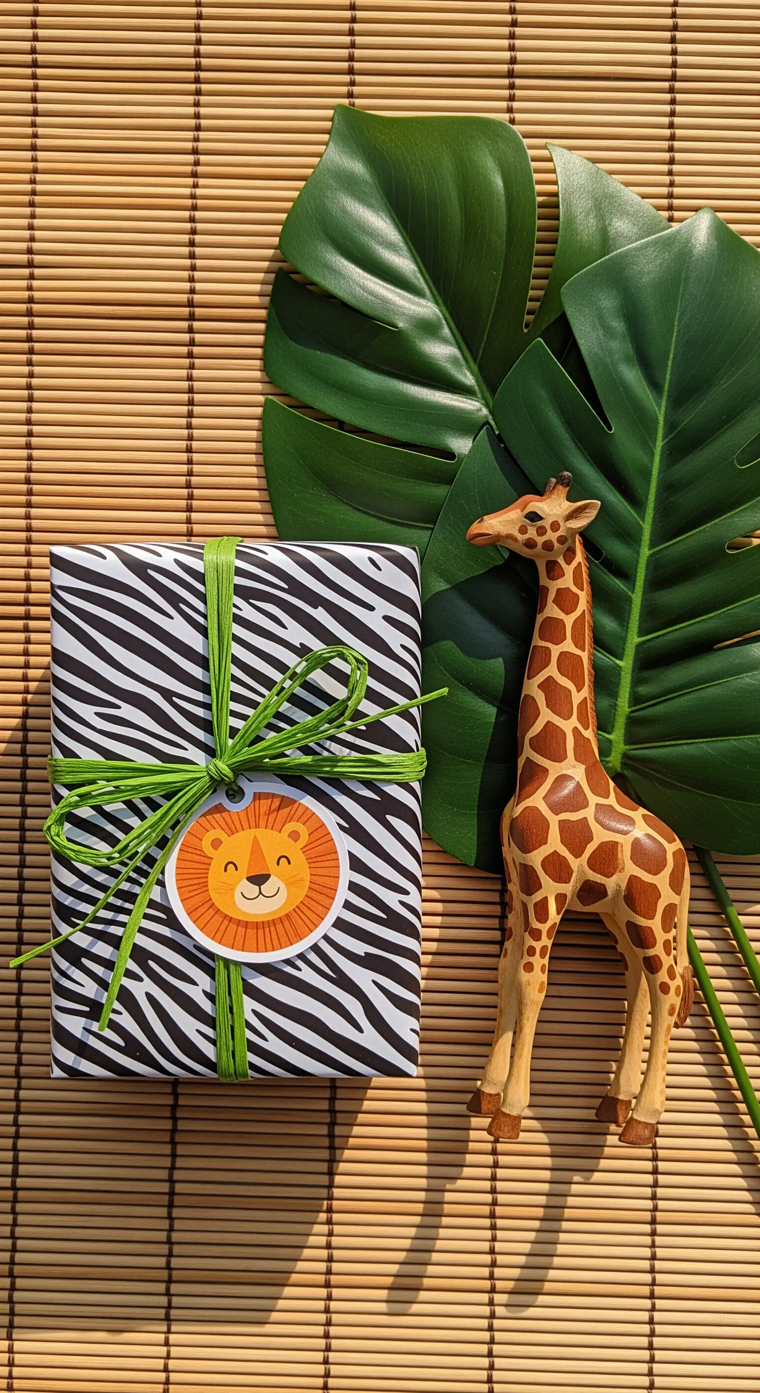 Pacchetto regalo con carta zebrata, nastro verde e un adesivo con un leone.