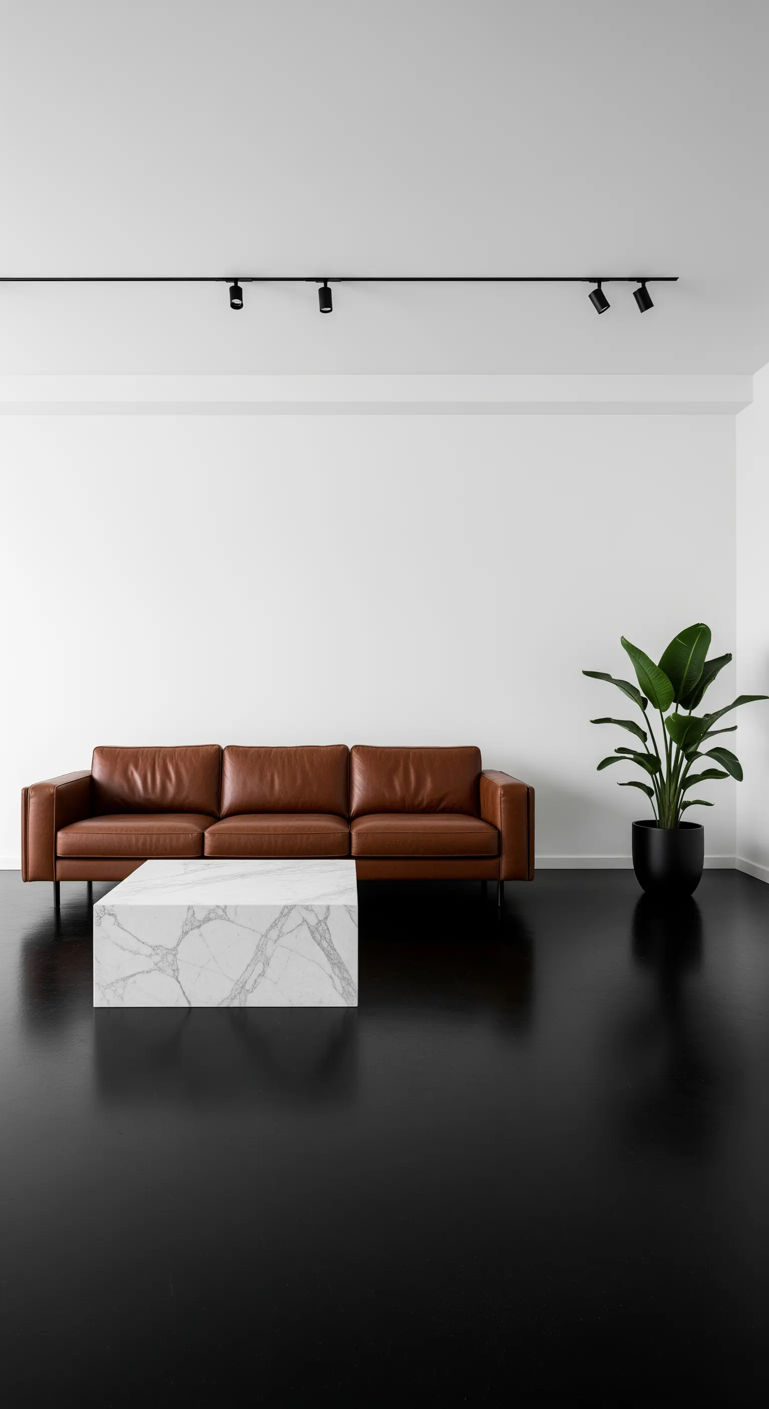 Spazio minimalista con divano in pelle, blocco di marmo e una sola pianta su pavimento nero.