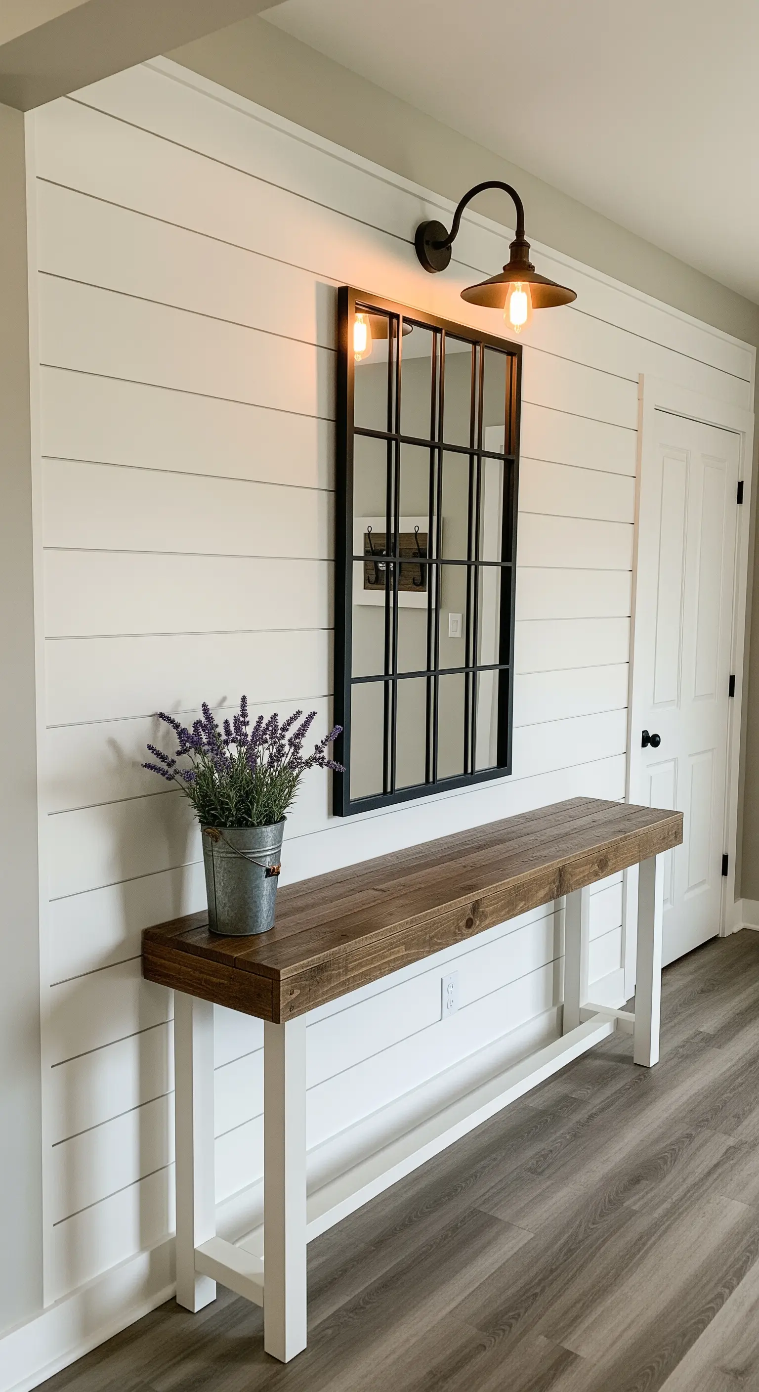 Consolle rustica su parete shiplap bianca, con specchio a finestra e applique industrial.