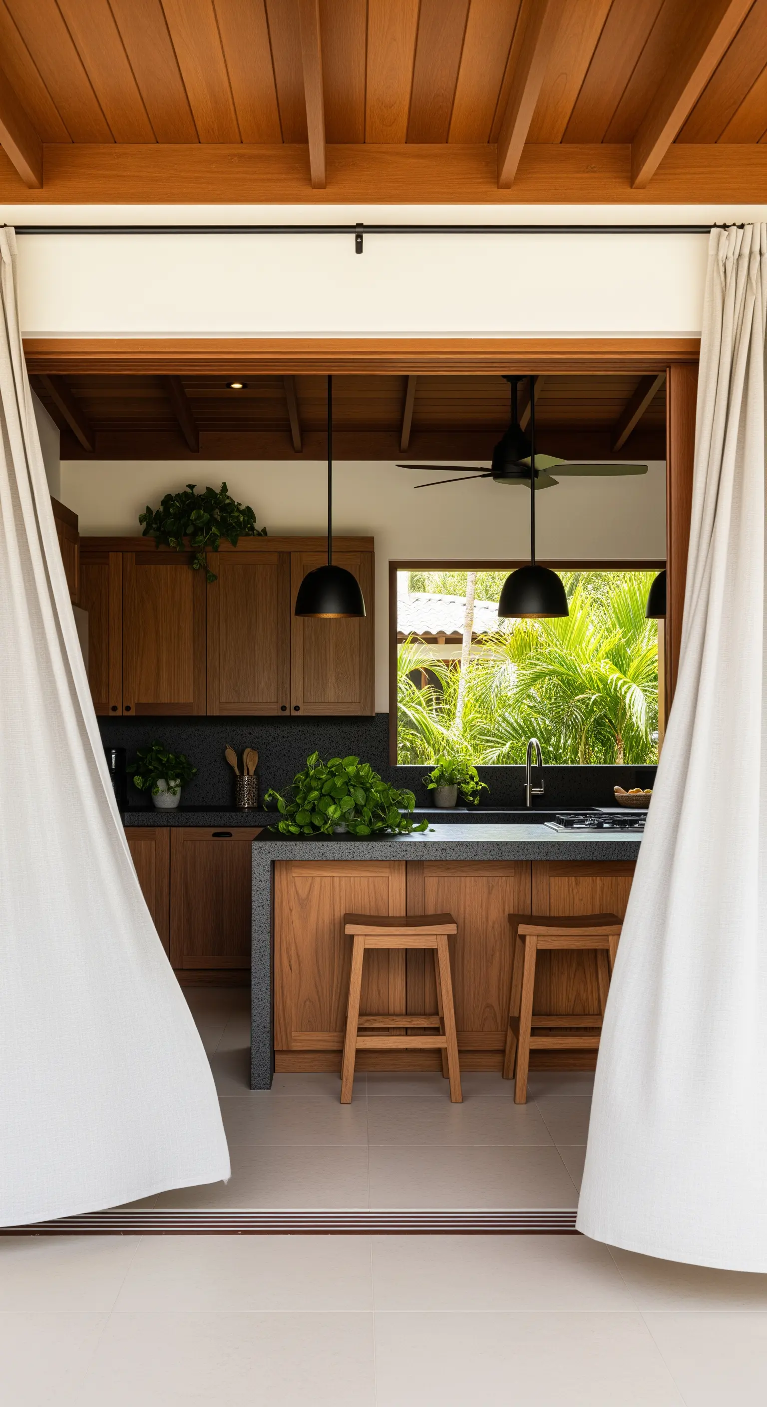 Cucina interna-esterna con tende bianche che fungono da separé.