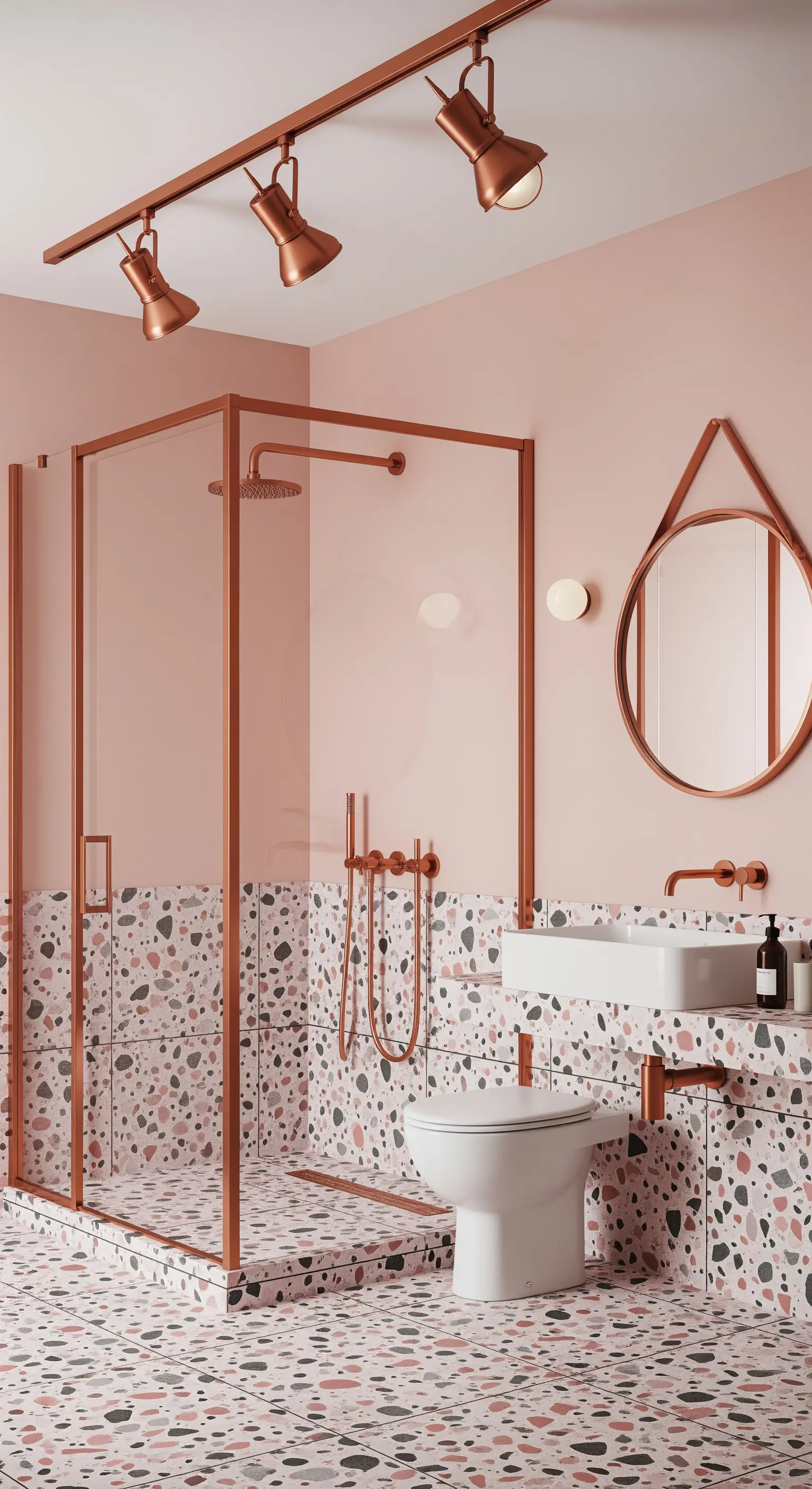 Bagno rosa con pavimento e parete in terrazzo, box doccia e faretti con finiture in rame.