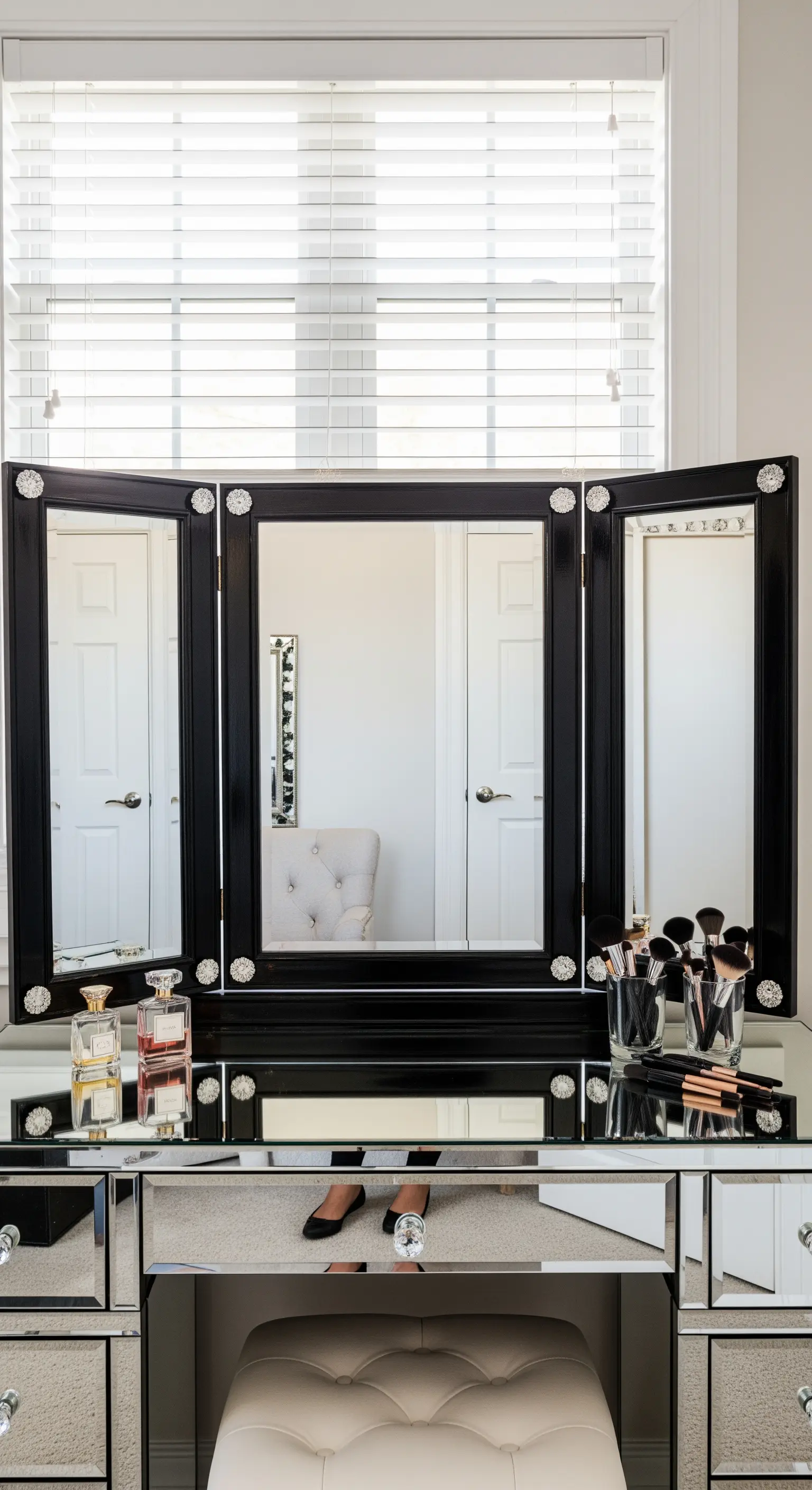 Specchio da trucco a tre ante realizzato con cornici nere e dettagli brillanti.