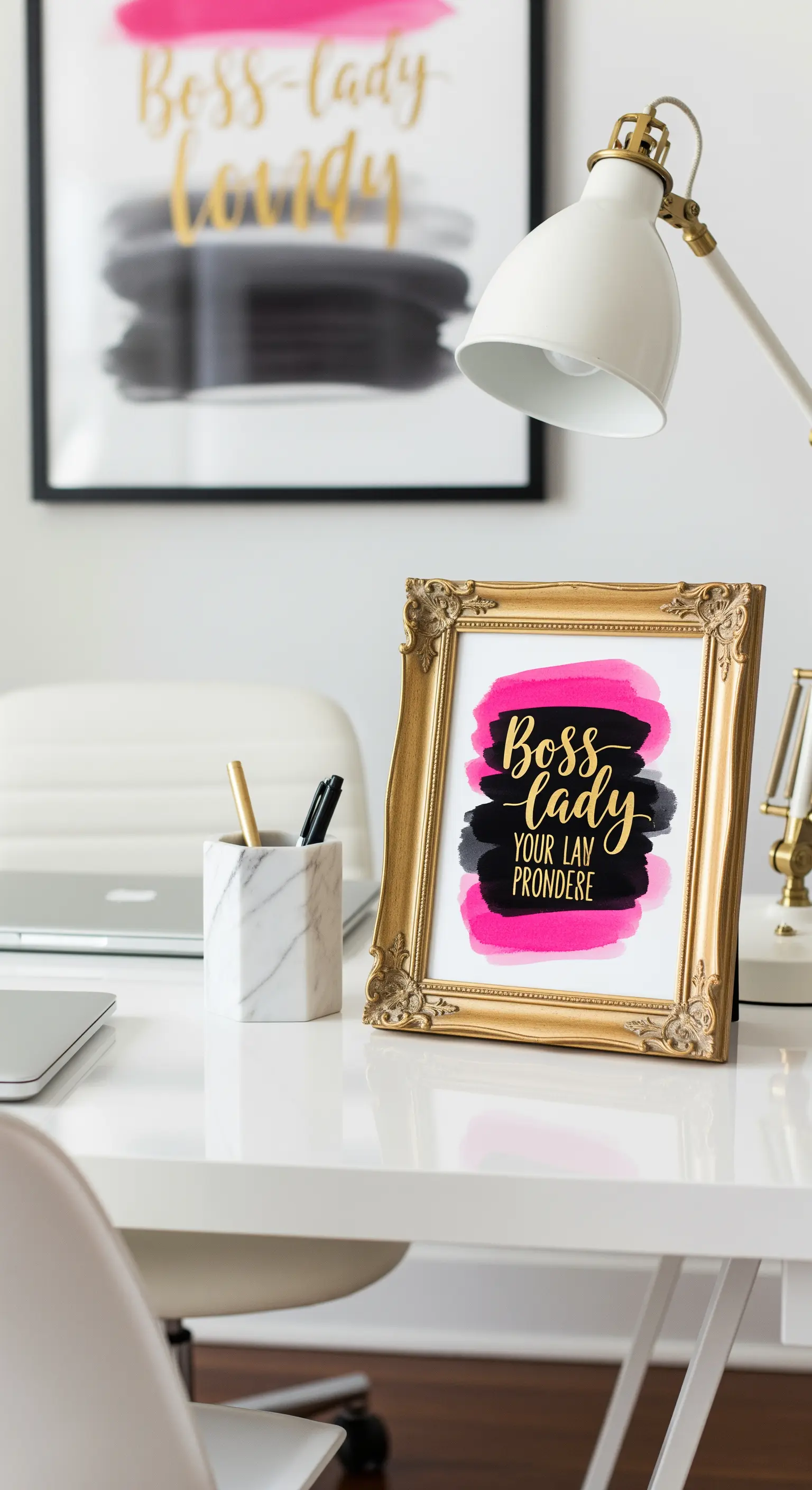Quadro con scritta 'Boss Lady' in oro su sfondo rosa e nero, in una cornice dorata su una scrivania.
