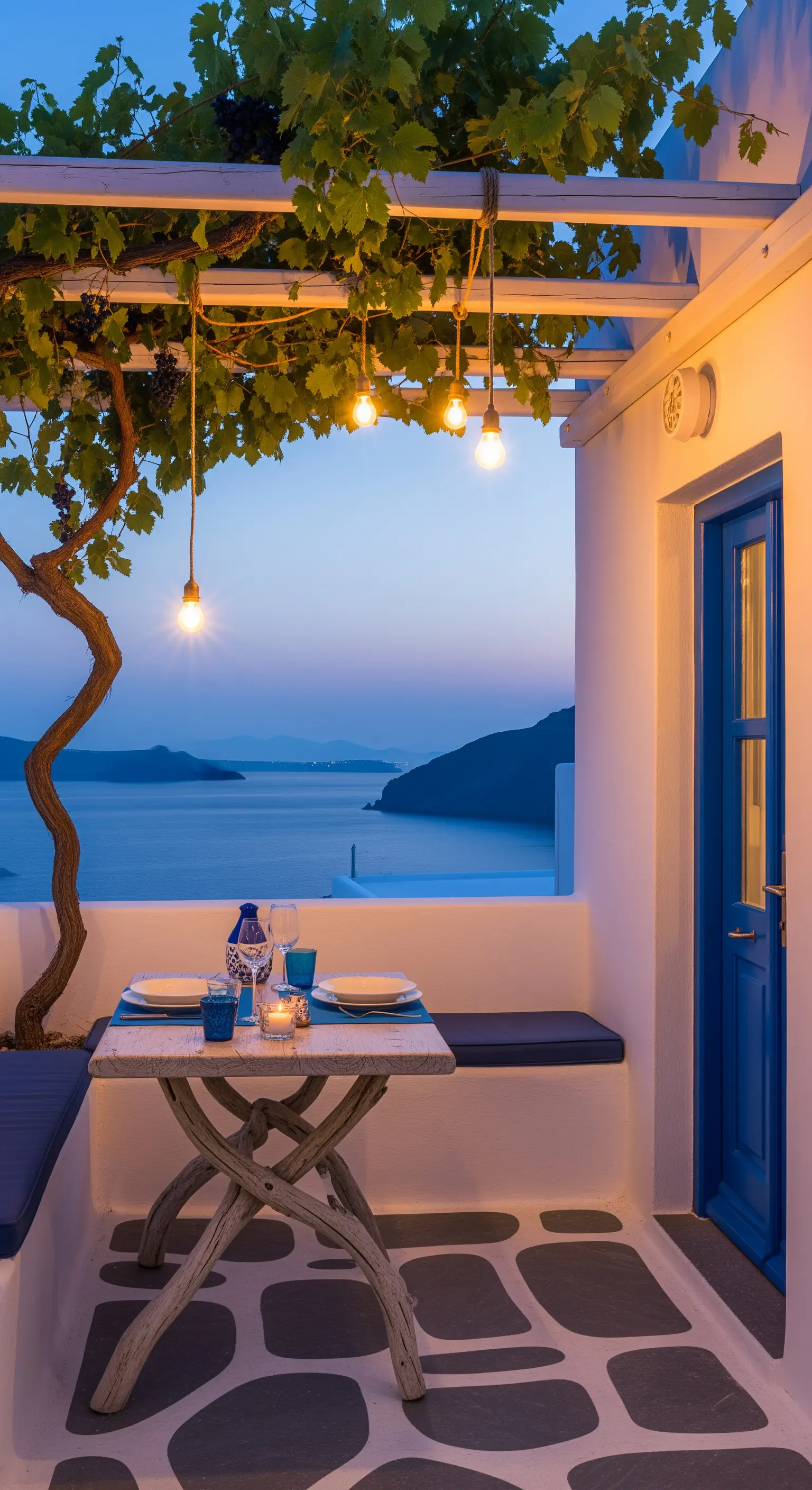 Balcone con vista mare, tavolo rustico e luci sospese da un pergolato di vite