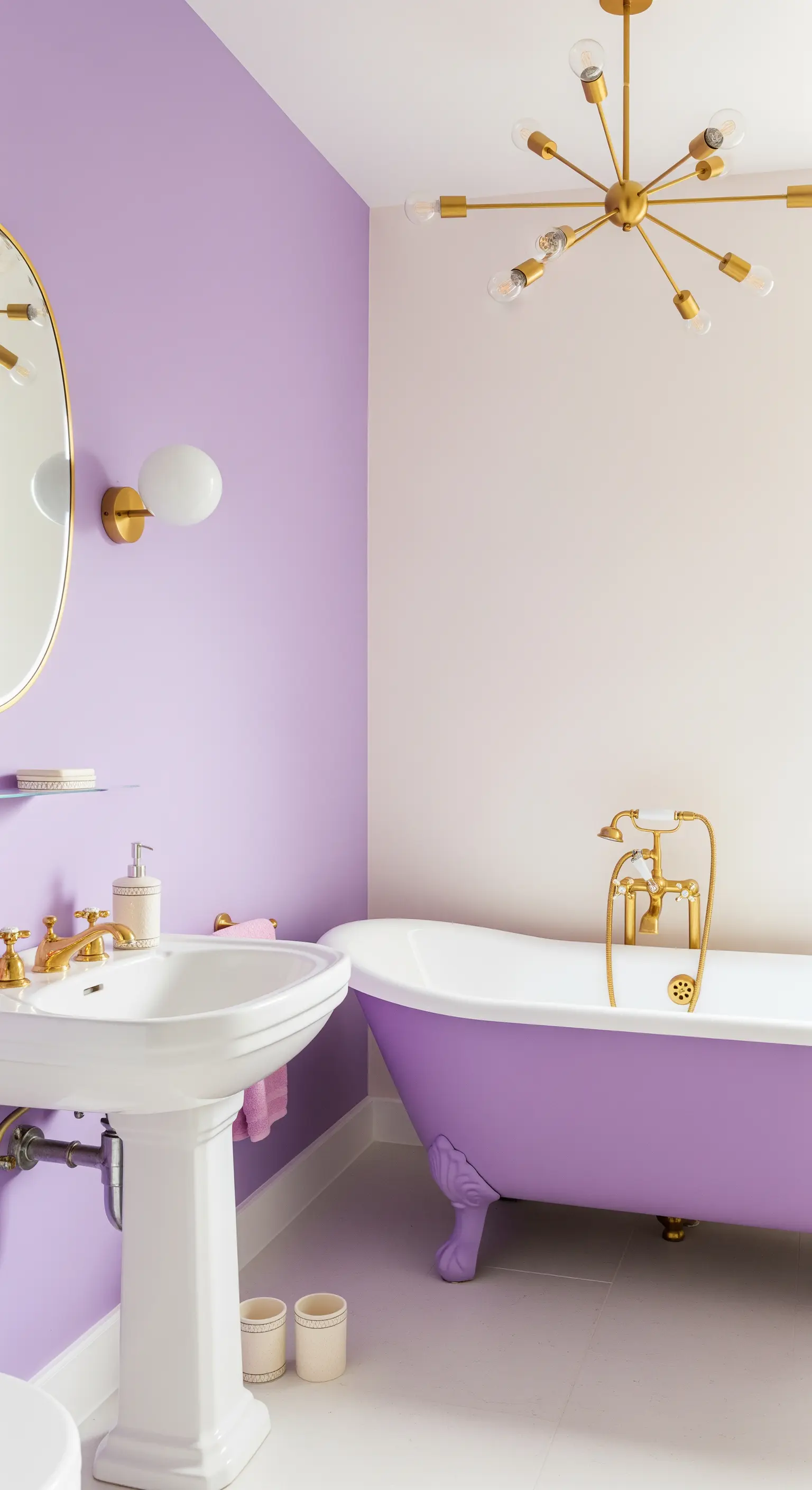 Bagno con parete viola, vasca viola con piedini e lampadario e rubinetteria dorati.